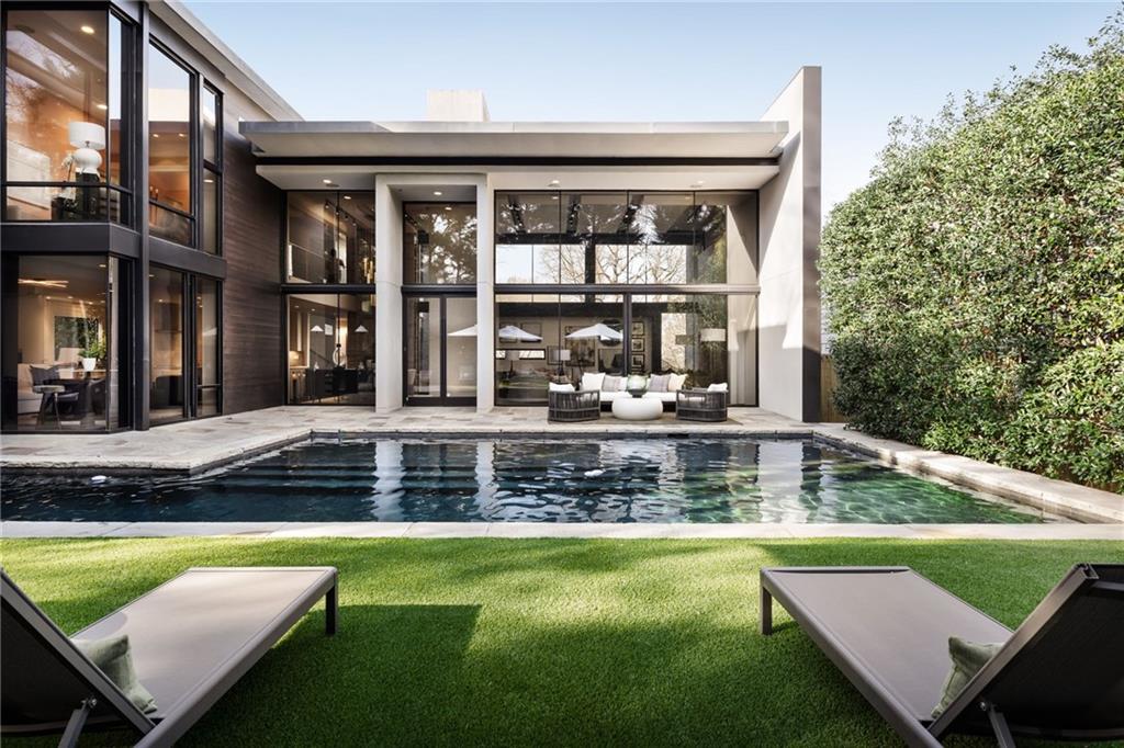 An amazing opportunity to own this award-winning modern masterpiece in Ansley Park. Widely recognized as one of Atlanta’s most iconic modern residences, this home is a multiple design award-winning architectural property. Jim Choate, renowned architect, created this contemporary iconic modern residence and Robert Tretsch with Harrison Design is responsible for the renovation architectural work completed in 2022 adding additional square footage to the home including a private balcony/deck off the 2nd floor primary suite. This contemporary masterpiece has a striking material palette that includes western red cedar, zinc, IPE hardwood, Tennessee bluestone, and solid wenge flooring seamlessly blending modern aesthetics with natural elements. No expense was spared with custom Bontempi Italian kitchen, floor to ceiling fireplace, wine cellar, private first floor guest suite, primary bedroom suite with sitting area and spa bath with beautiful custom closet, two additional ensuite bedrooms upstairs, and bedroom/office suite on main floor. Outdoors provides a luxurious retreat with heated saltwater pool, half bath, and an outdoor kitchen. Perfectly positioned in Ansley Park, this extraordinary home offers walkability to some of Atlanta’s finest restaurants and cultural attractions. Close access to Piedmont Park, High Museum of Art, Colony Square, Atlantic Station, and renowned Ansley Golf Club. Easy access to I-85 and I-75. A rare opportunity to own an award-winning residence that sets the standard for unique modern design in one of the most desirable neighborhoods.