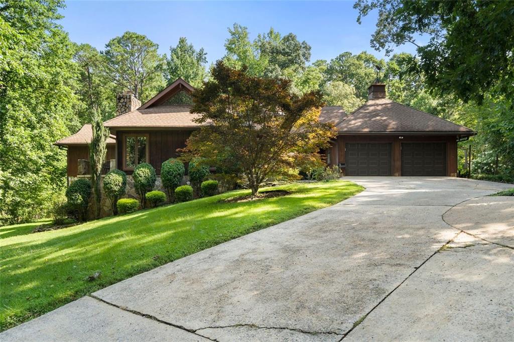 Discover your private sanctuary in Douglasville's best-kept secret, Valli-Hi Estates. This custom-built 4 bedroom and 4 bathroom traditional home provides 4,400 square feet of beautifully appointed living space. Step inside to a stunning great room featuring vaulted, beamed ceilings, oversized windows to let in the sunlight, rich hardwood floors, and one of two cozy fireplaces. Formal dining area flows into the open concept, cozy family room overlooking the gourmet kitchen with an abundance of storage with soft close drawers- centered around a spectacular 12-foot granite island and equipped with a professional gas cooktop, stainless steel appliances, a coffee bar, and a wine bar. The huge primary bedroom and spa-like en suite bath with double vanity granite counters, custom tiled shower, and separate granite surrounded soaking tub are conveniently located on the main floor. A second versatile bedroom and full bath on this level provides the perfect space for guests, a home office, or multi-generational living. Upstairs, discover two oversized bedrooms and a breathtaking, custom-tiled bathroom also with double vanity granite counters, stand alone soaking tub, and tiled shower. Venture down the unique spiral staircase to the finished daylight basement with yet another custom tiled bathroom with soaking tub. This bright, open space, with direct access to the grounds (and pool), is your blank canvas for a home gym, media room, or the ultimate poolside lounge.
Your outdoor paradise awaits. Spend hot, sunny days lounging by the gorgeous in-ground pool, find tranquility in the stone courtyard with its classic fountain, relax on the balconies overlooking the grounds, or utilize the large workshop for your hobbies. This home seamlessly blends refined interior details with magnificent natural surroundings. Tucked away on FOUR secluded acres complete with blueberry bushes and two spring-fed creeks, this property offers serene country living while being just 25 miles from Hartsfield-Jackson Airport and 22 miles from downtown Atlanta.