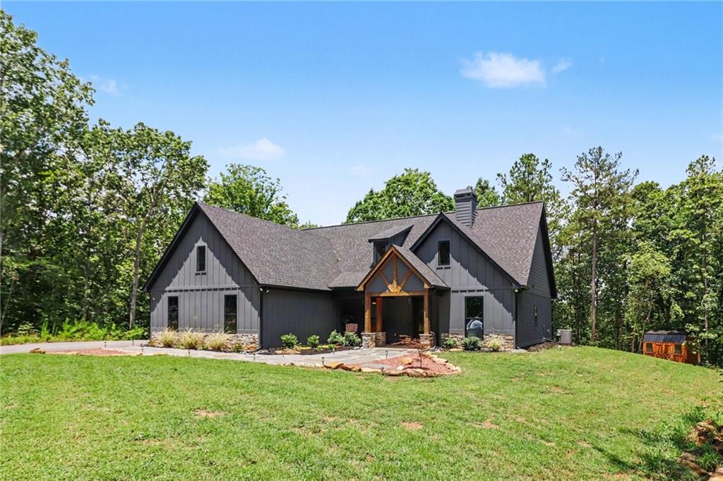 Modern farmhouse exterior featuring dark vertical siding and stone accents