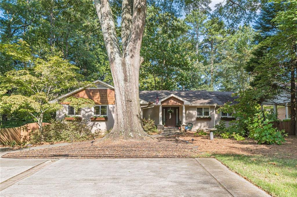 Welcome to this beautifully updated ranch style home nestled in the heart of Druid Hills, one of Atlanta's most sought after neighborhoods, just minutes from Emory University and Emory Campus Hospital. This home offers exceptional privacy in a serene setting while being close to everything and walkable to Emory Village. A wall of windows stretches across the back of the home, flooding the interior with natural light and offering peaceful views of lush surroundings. The spacious open concept living and dining room is perfect for entertaining or relaxing, with a seamless flow and warm, inviting atmosphere. The cheerful, white galley kitchen is bathed in sunlight and designed for both functionality and style. The generous primary bedroom easily accommodates a king-sized bed and offers a quiet, spa-like retreat. Two additional bedrooms provide flexibility for family, guests, or a home office. Ample off-street parking includes a convenient front parking pad and a rear-entry, 2-car, drive-under garage. This turnkey home blends classic charm with modern updates in an unbeatable location. Don't miss your chance to live in one of Atlanta's most beloved neighborhoods!