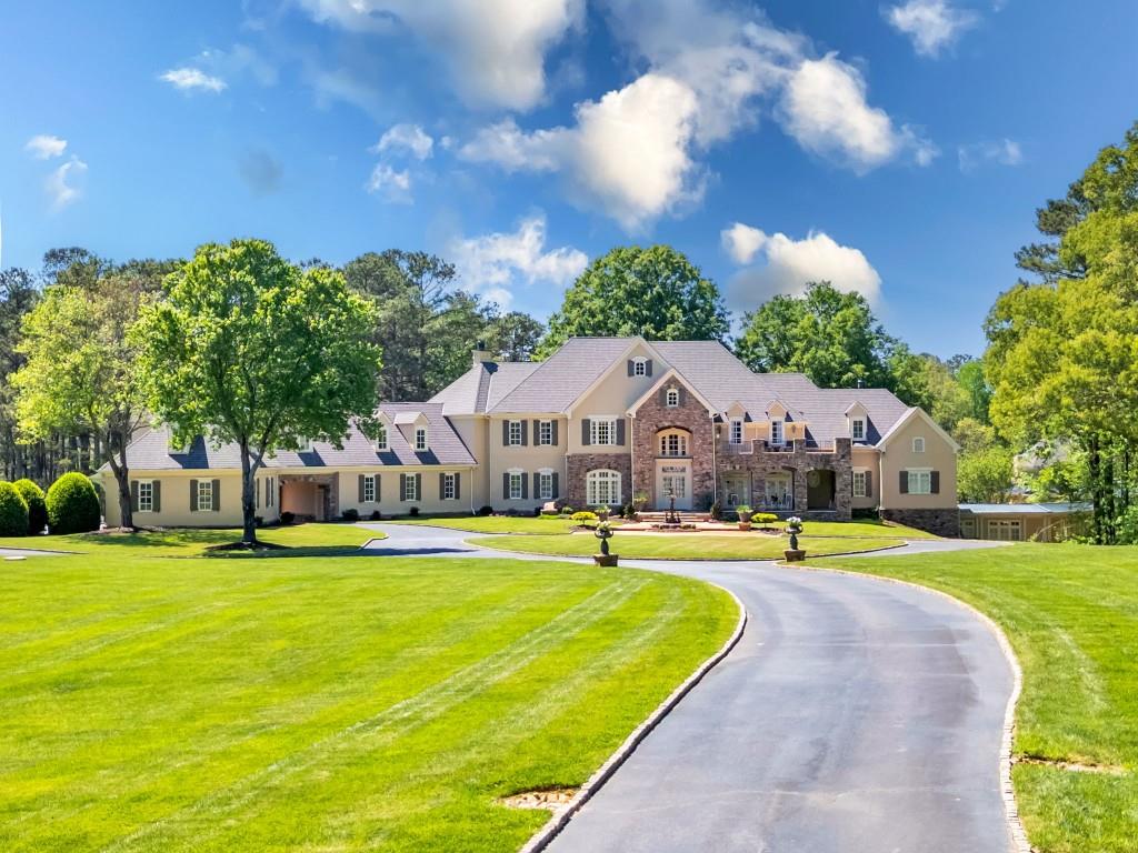 Step into an unparalleled realm of elegance at 10955 Stroup Road, where lakeside luxury meets architectural magnificence in this Stephan Fuller-designed estate. Nestled on 11.62 acres in Roswell's most prestigious enclave, this gated masterpiece boasts an expansive 26,000 square feet of sophisticated living space. Designed for the most discerning of buyers, this property features 6 bedrooms, 10 bathrooms, and an array of resort-style amenities amidst lush, meticulously landscaped grounds.  Be welcomed by a grand two-story foyer into the main level, awash in natural light. Twelve-foot ceilings, a palatial primary suite, and a large kitchen open to a cozy keeping room are just a few of the spectacular features of this home.  Tailored to accommodate every lifestyle, the upper level has four spacious bedrooms, each boasting an en-suite bathroom alongside a versatile bonus room. The lower level is a haven for entertainment and leisure with a home theater, billiards room, and fitness studio. The pi ce de r sistance is a spa oasis featuring a massage room, sauna, and steam shower. The estate also hosts a 25-meter olympic indoor lap pool, a soaking tub, and a convertible full court for tennis and basketball, adaptable for pickleball.  Security is paramount with a fortified gated entrance, reinforced steel construction, and a comprehensive emergency system, including a generator and lightning protection.  Located just minutes from top schools and the vibrant Canton Street, this estate offers the perfect blend of seclusion and accessibility.