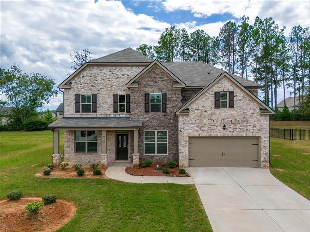 Step into your dream home! This exquisite 5-bedroom, 3-bathroom residence, built in 2022, boasts a charming brick and stone front. The inviting front porch leads into a bright and airy interior, while the back porch provides a perfect retreat for outdoor relaxation. Step inside to discover the spacious layout, featuring coffered ceilings that add a touch of sophistication to the living areas. The heart of the home is the gourmet kitchen, complete with an island and luxurious vinyl tile flooring, ideal for both everyday living and entertaining.Convenience meets comfort with an in-law suite located on the main level, perfect for guests or family. The living room features rare trey ceilings, creating an elegant atmosphere for gatherings.Spanning over 3,000 sq. ft., this home offers plenty of space for everyone.With two HVAC units for optimal climate control, this home is designed for comfort year-round. The community amenities include a refreshing pool, tennis court, clubhouse, and scenic walking trails, ensuring a vibrant lifestyle. Just off Hwy 42 with easy access to I-75. It's approximately 9 mins from Tanger Outlet