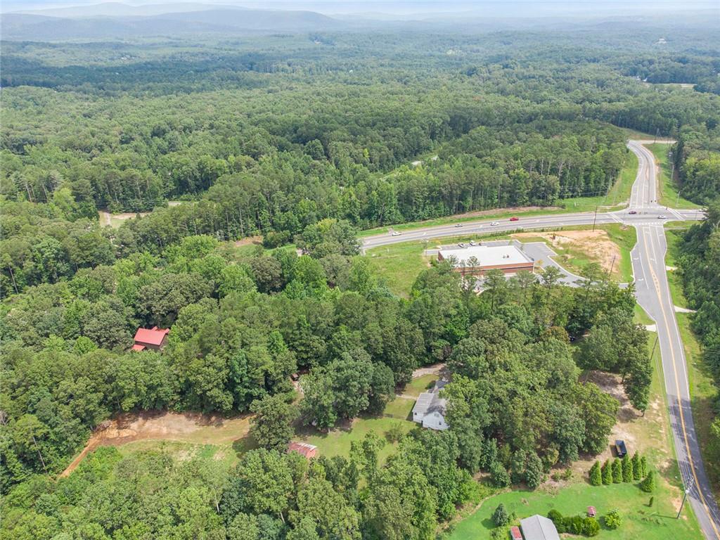 Great opportunity in this rapidly growing Cherokee County. Zoned General Commercial and located at the intersection of GA State Hwy 20 and Hwy 108 (Fincher Rd) between Canton and Cartersville next to newly constructed Dollar General Store.. Lake Allatoona is close by. Adjacent properties are also zoned general commercial with possible opportunity to assemble other tracts. This would be a great location for a gas station, storage facility, dry storage for RV's and boats, etc.... possibilities are endless. There is a farmhouse nestled on this 4.88-acre property in Sutallee that offers the perfect blend of rustic charm and commercial potential. With 4 bedrooms, 2.5 bathrooms, and a spacious 3,000 square feet, this property is a true gem. Step inside and be enchanted by the farmhouse's inviting ambiance, complete with a cozy family room featuring a fireplace and exposed beams that exude warmth and character. Beyond the charming living spaces, the property boasts a barn, pasture, and an abundance of fruit trees, creating a picturesque mini-farm setting. But the real draw is the property's commercial zoning, making it an exceptional opportunity for those seeking to establish a thriving business in a serene, countryside location.