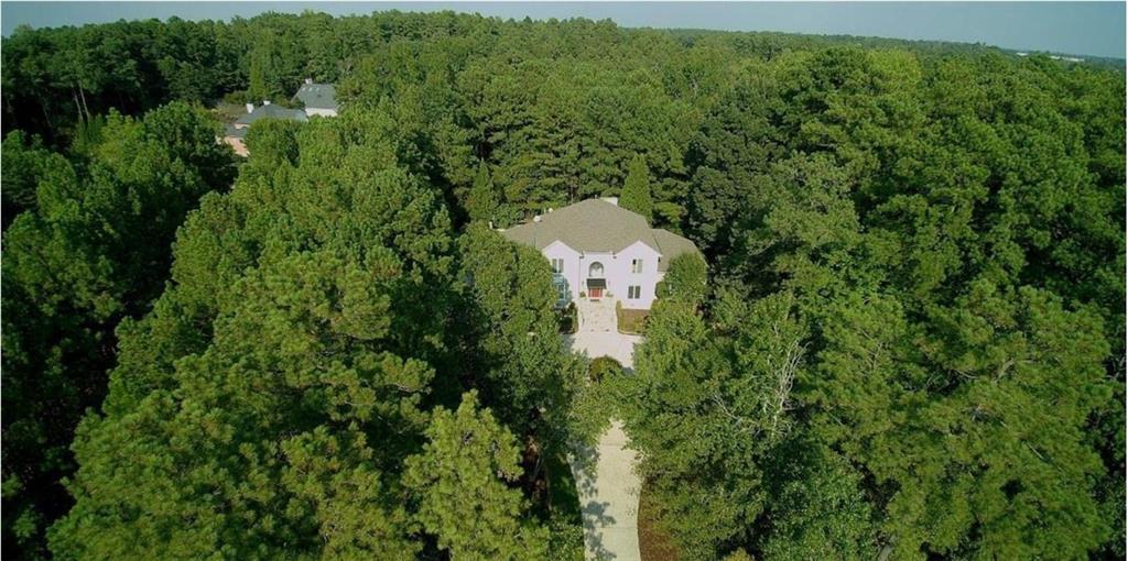 Indulge in timeless luxury at Lake Spivey. This fully renovated 4bedroom, 5bath estate offers over 4,200 square feet of grandeur on nearly two acres - surrounded by multimilliondollar estates and directly next to a brandnew $1.8M home. From the moment you step into the dramatic two story foyer with soaring 20 foot ceilings and a stunning chandelier, you feel the scale and sophistication of this home. The main level flows seamlessly into both formal and casual spaces - a richly detailed dining room, an elegant living room or office, and a sunlit great room with a custom builtin chic bar and fireplace. The gourmet kitchen is a true centerpiece, boasting new countertops, custom cabinetry, premium stainlesssteel appliances, and a breakfast area with builtin desk nook - perfectly blending beauty and function. The primary suite on the main level is a retreat unto itself, with vaulted ceilings and a newly renovated spalike bath featuring a freestanding tub, glass walkin shower, and sleek modern finishes. Upstairs, a second primary suite offers flexibility for guests or multigenerational living. Every detail has been considered - all new windows throughout, a brandnew septic system, new pool pump, rich flooring, plush carpeting, and crown molding. Step outside to your private oasis: an expansive deck overlooks the sparkling saltwater pool with a fully motorized cover, surrounded by a manicured lawn, circular driveway, and additional parking pad. This isn't just a home - it's a lifestyle. Surrounded by new and established milliondollar estates, this property is priced to offer unmatched value for the location, size, and updates.