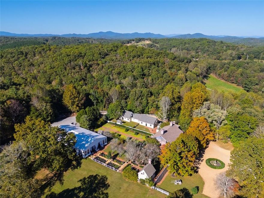 Incredible opportunity for a developer/JV partner, new urbanist design team, hospitality business, or a family who wants the most phenomenal estate and private mountain escape - there is nothing like this on the market, not just in Blue Ridge, but anywhere! Just over an hour north of Atlanta, this 38.6-acre property known as "Inola" is nestled in a forest. This property has the potential to be a one-of-a-kind, first in Blue Ridge, new urbanist style development and is the world’s largest collection of exact replica Colonial Williamsburg buildings. The property is just 1 mi from downtown Blue Ridge, seen by over 500,000 visitors each year to neighbor Mercier Orchards, only a 4 mi drive to Lake Blue Ridge, and surrounded by all the natural amenities of the Blue Ridge mountains. Inola is teeming with opportunity in the heart of the fastest growing luxury mountain town in the South. JV opportunity for an entrepreneur or hospitality group could capitalize on the thriving special events business that is already booking weddings for 2026. The current owner/operators will stay on as operators, minority equity owners & consultants, or whatever scenario is amenable to all parties. The owners have master land plans from the famed designer Jeff Speck, land planner for Rosemary Beach and many other developments.The current owners worked with internationally renowned land planners and architect Stephen Fuller to develop plans for homes to be built in either the traditional new urbanist town style, or a traditional neighborhood with only 10 estate lots. If you have a developer's vision, you'll recognize Inola as a ripe opportunity. Buildings include homes, a 90-seat chapel surrounded by formal English gardens and a 6,000 SF event space, stables, barns, tavern/inn, post office, and shops along the roughly 1/4 mile long "main street" with pea gravel roads and white fences all looking over the 3+ acre Sugar Lake, replete with trophy bass and large koi. The colonial buildings are the most period-perfect in the U.S., handblown windows, 300-year-old wood floors, exquisite moldings and appointments, 16 fireplaces. Each brick is the correct color, size and number of bricks for the facades and were meticulously recreated over a 10-year construction period. Built by an eccentric visionary in the 1980s with construction management by the town architect from Colonial Williamsburg VA painstakingly recreated the village. The current owners have thoughtfully renovated and improved the landscaping and building interiors using an elegantly appointed chic modern flare. The estate has taken on a new life as an upscale mixed-use new urbanist property with weddings, special events, and a desirable movie location. The focal point of the property is the Wythe Mansion, an impressive exact replica of the famous Williamsburg estate. The newest addition is a 2,000 sq ft luxury suite on the top floor that is ready for custom finishing. In total, there are over 15 bedrooms, 12 full baths, and 5 1/2 baths in 4 residences on the property. Voted as "Best Destination Wedding Venue in Georgia '22, '23 & '24" by Jezebel, '23 “Best Destination Wedding Venue for the S.E and Caribbean” by Modern Luxury Weddings, and "Couples Choice Award '22, '23 & '24" by readers of Wedding Wire & The Knot and many more accolades - Inola has a successful, built-in special events business, with room to grow. "Wetherburn's Tavern" is an exact replica of the Williamsburg famed Tavern and Inn, with event space for up to 75 and guest suites. The 6,000 square foot, opulent Orchard Pavilion and adjoining formal gardens can seat up to 300 guests and overlooks beautiful pastureland and 3+ acre Sugar Lake. Infrastructure can perfectly accommodate large events, with wifi throughout the grounds, plenty of parking, pea gravel covering 90% of the roads, all underground utilities, three phase power, and 1 gig of fiber. This is a rare opportunity for an irreplaceable business development or private estate.