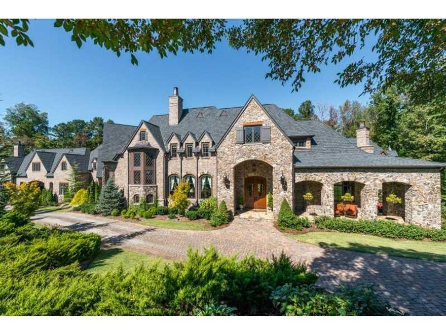 Beautiful stone home in Suwanee's desirable River Club neighborhood. This stunning home boasts only the finest and most elegant finishes. Exquisite moldings, grand spaces, and fantastic outdoor living rooms. Luxuries include: cathedral ceilings, gourmet kitchen with huge center island, barrel vaulted master bedroom, sauna, lower level kitchen, custom bar, theater room, outdoor kitchen, pizza oven, wine room, gym, 4-car garage, and more! Impeccably designed.