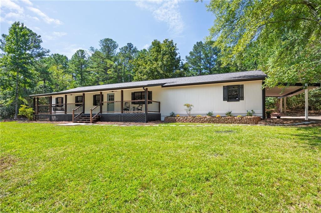 Discover your own private homestead on nearly 4 acres in sought-after North Paulding. This beautifully renovated single-level home offers three spacious bedrooms, two modern bathrooms, and a sunroom. With over $85,000 in improvements, every detail has been thoughtfully updated, including new LVP flooring, kitchen cabinets, appliances, bathrooms, lighting, PEX plumbing, HVAC, and septic. A two-car garage provides both convenience and storage. Outdoors, the lifestyle is unmatched. The enclosed garden is ready for your vegetables and flowers, while trails wind through the 3.7 wooded acres for you to explore. Deer make nightly visits, adding to the peaceful atmosphere, and both the covered back porch and the rocking-chair front porch provide relaxing spots to enjoy the surrounding nature. With no HOA restrictions, this property offers the freedom to create the homestead you’ve always dreamed of while still being close to top schools, parks, and amenities in North Paulding. This rare opportunity combines modern comfort, privacy, and room to grow—inside and out.