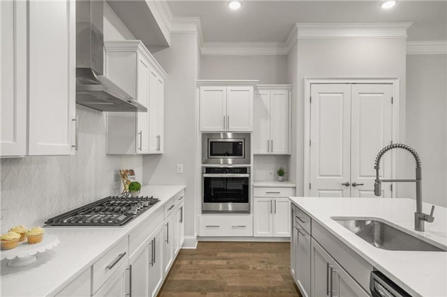 Better than NEW!!  The Perfect home in the perfect location!!  When you step into The Frisco, you'll feel right at home with its modern and stylish layout, 10ft ceilings and hardwood floors thru-out. The open-concept kitchen/dining/family room will ensure you'll have plenty of space for entertaining and relaxing. The kitchen features an oversized island with beautiful quartz countertops, soft close cabinetry and stainless steel appliances ensuring a dream culinary experience.  Don't miss the custom closet walk-in pantry.  Bright open family room features a gorgeous linear fireplace and wall of windows.  Upstairs, you'll find the secluded large owner's suite complete with walk-in custom closet designed by Spacemakers, large spa-like ensuite bathroom with separate vanities and gorgeous glass framed shower.  Relax on the private covered deck just off your Owner's Suite for your morning coffee. Just down the hall are two more spacious bedrooms each with walk-in closets and an additional bathroom. But we're not finished yet!  This home features a private fenced backyard with woods behind.  More bonus features -- additional parking across the street for guests.  This home has all the upgrades - wide plank engineered floors, designer tile, stainless steel appliances including refrigerator and W/D, lighting, quartz counters, custom closets! Hurry to see this meticulously maintained home just minutes to vibrant downtown Woodstock's many dining, shopping and entertainment amenities.  Come tour this beautiful home and see the ease of lock and go living!