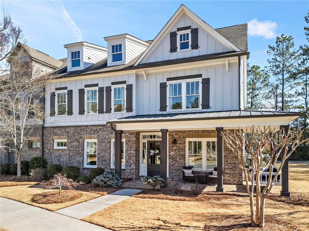 Rare opportunity for an end-unit, primary suite on main townhome in desirable Crabapple locale! This home offers the best of both worlds; it lives like single-family but without the hassle of extensive upkeep! Friends and family alike are greeted by the southern wrap-around front porch and immediately taken back to a slower pace of life. Inside, this home boasts countless upgrades around every corner like an impressive trim package, upgraded flooring, brick accent walls, designer wallpaper and upgraded fixtures. Gourmet kitchen is the hub of the home with high-grade cabinetry, walk-in pantry, Thermador gas cooktop, double ovens, massive island, and separate beverage center in the breakfast nook. The copper pot filler impresses any at-home chef and doubles as a piece of art! Drenched in natural light, the fireside family room beckons for entertaining a crowd. The primary suite on the main level is a serene oasis fit for royalty! Luxurious en-suite washroom featuring dual vanities, free-standing tub and large tile shower plus direct access to the private first floor laundry room and two walk-in closets, both with custom cabinetry. Head upstairs to find a second living room and a second laundry room - no toting hampers up and down the stairs here! Four additional guest bedrooms all showcase ample natural light, large closets, and direct connectivity to the three full bathrooms upstairs. An additional bonus room, currently used as the kids’ playroom, offers endless options for an office space, media room, or home gym. Outside, the covered back porch is a perfect spot to unwind after a long day and the (two) porch swings are staying with the house! Flat and landscaped backyard and side yard CAN BE FENCED, happy to share quote! Meticulous Sellers have also recently replaced both HVAC units (2021 and 2024) and cared for this home with extreme attention to detail. You will be hard pressed to find a better location; between the close proximity of all of the fun shopping and restaurants in Crabapple Market to the highly-rated schools of Crabapple Crossing Elementary, Northwestern Middle and Milton High, this one checks all the boxes. Welcome home to 1565 Parkside Drive, where life is good and living is easy!