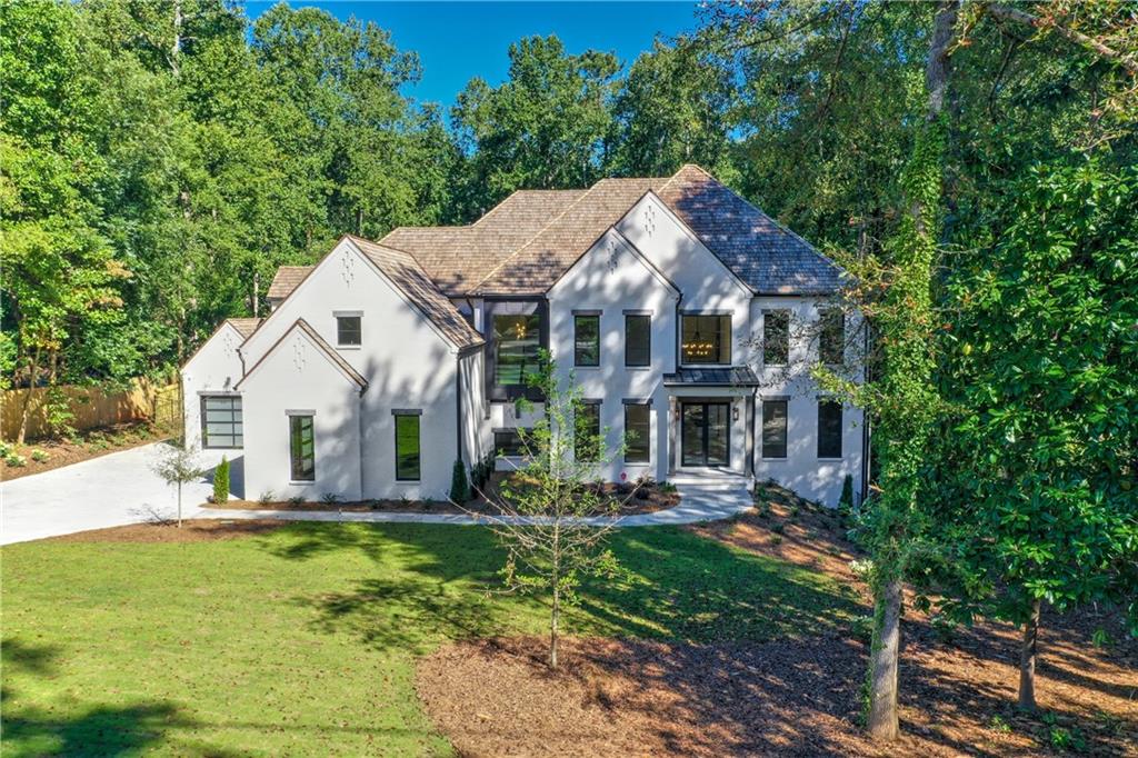 Exclusive Rosen Construction build in fabulous Sandy Springs. Walking distance to Chastain Park but none of the traffic. A luxurious, modern home with awe-inspiring views at every turn. Situated on an expansive 1+ acre lot and enveloped by natural forest, this stunning estate boasts maximum privacy with ultimate luxury. Retreat to the tranquil yard featuring a sparkling pool seamlessly blending into the horizon and ample patio and grass space for dining and/or lounging al fresco. Features include lavish dual master suites with dual baths large closets, well-appointed guest suites, elevator, movie theater, gym, lower-level game/entertaining, two laundry rooms, Four car garage, au pair suite, multiple fireplaces, playroom, covered porch to walk out heated Pebble-Tec pool and spa. Stunning painted 4-sided brick, commercial grade Quaker metal windows, 6” rounded gutters, Cedar Shake roof, white oak 7’ floors, tankless water heater and so much more. Only moments from Chastain Park, Buckhead, Vinings and downtown, this Chastain Park estate is truly one to behold. Take the elevator to the basement and WOW you see this absolutely amazing, finished basement. Kitchen features white marble, high end appliances like Wolf, Sub-Zero, Bosch, Ice Maker, Wine cooler, and walk in pantry. Covered porch overlooks the stunning in-ground pool. This home has so much to offer from upgraded trim to lighting package to cabinets and appliances. Are you looking for a larger garage? We have a 4-car garage with long driveway for entertaining! This is a very private gated lot and custom home that is second to nothing. Photos are for reference only.