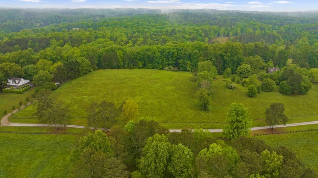 Discover 4.89 acres of prime land in one of Cherokee County's most desirable locations, featuring the convenience of an Alpharetta address. Nestled on a gentle rise, this parcel captures breathtaking views and offers a tranquil setting with a balance of pasture and mature hardwoods. The property provides an ideal homesite for a custom estate, weekend getaway, or future investment. Enjoy the privacy of acreage living without sacrificing proximity to excellent schools, shopping, and dining a rare opportunity to create something truly special.