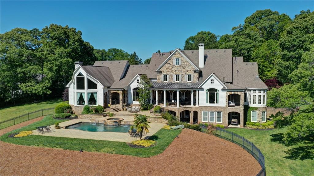 Private, custom built estate home situated on 21.9 acres in a prime Milton location. The property made up of green pastures and wooded areas to protect it's privacy, is completely fenced with 4 board fencing and has a gated entrance. This home, with architectural details throughout and over 7,000 sq ft, is an entertainer's dream with an open floor plan and great indoor and outdoor living spaces. The main level consists of an entry way with a barrel ceiling and foyer with a marble floor inlaid decorative motif* the owner's suite which includes a breakfast bar, large custom closet, luxurious spa, sitting area with marble fireplace, and a private porch overlooking the property* a large dining room for entertaining guests* gentleman's study with a fireplace and coffered ceiling* a living room with stone fireplace and soaring high coffered ceiling that opens to an outdoor covered veranda with fireplace that overlooks the pool and scenic views of the pastures with a wooded backdrop* chef's kitchen with top of the line appliances with an adjoining second/prep kitchen* and a one of a kind family room with full bar and floor to ceiling stone fireplace. The second level hosts 3 secondary, ensuite bedrooms, all with their special design and features. Semi-finished basement. Additional structures on the property include an updated 2 bedroom guest home and a 4 stall barn.