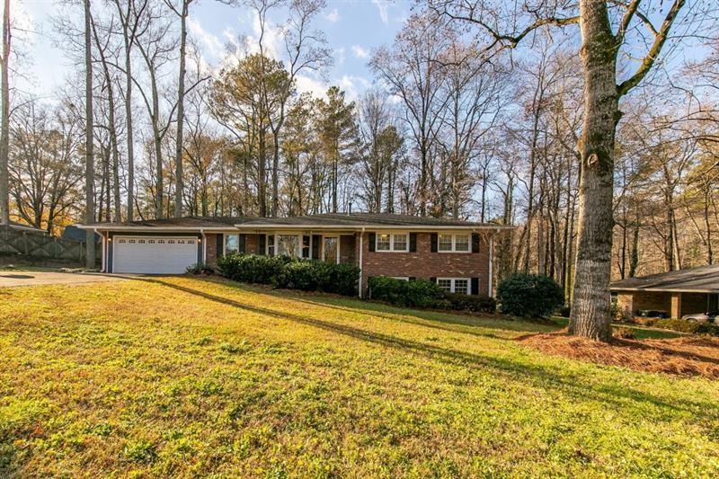 Stunning Renovated Ranch with Finished Terrace Level in the Heart of Kennesaw! Welcome home to this beautifully updated open-concept ranch, perfectly situated within walking distance to Downtown Kennesaw, Depot Park, local shops, and delicious BBQ! Step inside to find gleaming refinished hardwoods and a bright, airy layout. The completely remodeled kitchen is a showstopper -- featuring new white cabinetry, granite countertops, a stylish backsplash, newer stainless steel appliances, and a long breakfast bar that opens to a spacious living room with bay window (perfect as a flex space) and a large dining area. The oversized great room offers warmth and charm with a cozy fireplace flanked by custom built-ins. All three main-level bedrooms feature hardwood floors and share two fully renovated bathrooms. The terrace level is brand new and spectacular! Enjoy smooth ceilings, two additional bedrooms, a beautifully upgraded full bath, and a huge media/rec room wired for surround sound with soundproof ceilings -- ideal for movie nights or entertaining. Additional features include: Newer HVAC & water heater * Upgraded plumbing and electrical systems * Enclosed carport converted into a garage. Massive out-building with electricity and water -- perfect for a workshop, studio, or storage. This one has it all -- style, space, and an unbeatable location!