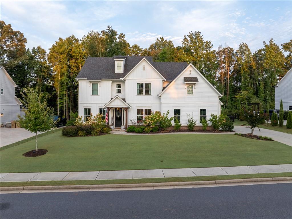 Stunning 2020 custom-built home offering almost 4k Sq Ft of meticulously designed living space with soaring 10' ceilings and elegant 8' doors throughout the main level. This 4-bedroom, 3.5-bathroom residence showcases premium finishes and thoughtful custom details at every turn.
The chef-inspired kitchen is perfect for entertaining and features an oversized island with extensive storage, gas range, and seamless flow to a large walk-in custom butler's pantry complete with fully custom cabinetry, distinctive herringbone brick flooring, white oak countertops and a freezer. Built-in dry bar off the kitchen includes wine refrigerator for elegant entertaining. Mudroom provides organized living with custom-built cabinet lockers and drawers that offer plenty of storage.
Formal dining room impresses with coffered ceiling and classic wainscoting, while the shiplap-adorned living room offers custom built-in shelving for sophisticated entertaining. Main level office features custom built-ins with drawers and white oak desktop for the perfect work-from-home environment. Playroom with closet provides flexible space that could serve as an additional bedroom. Powder room showcases Pottery Barn vanity and charming shiplap detailing.
Upstairs, the primary suite has been upgraded with hardwoods and shiplap, complemented by expansive walk-in closets with custom shelving and abundant storage. Fully custom upstairs office includes hardwood flooring, built-in cabinetry, and electric fireplace for an inspiring retreat. Guest bedrooms feature board and batten accent walls, each thoughtfully designed for comfort and style for a large family.
The professionally landscaped and fenced grounds create an entertainer's paradise with multiple outdoor living areas. Expansive covered deck off the kitchen flows seamlessly to a covered outdoor kitchen equipped with built-in griddle and smoker, granite countertops with storage underneath, and wall-mounted TV, all featuring elegant herringbone brick flooring. Two distinct firepit areas—one brick, one freestanding—anchor the beautifully designed outdoor spaces. Children's playground area features timber-framed mulch play zone for safe family fun. Brand new freestanding workshop building with electrical provides organized storage and functional workspace tucked away in the trees.
Recreation enthusiasts will appreciate the 2-hole Bermuda putting green, perfect for honing your short game. Professional landscape lighting illuminates both front and backyard areas for year-round enjoyment. Three-car garage with large storage shelving completes this exceptional property, combining luxury living with practical functionality in a thoughtfully planned design.