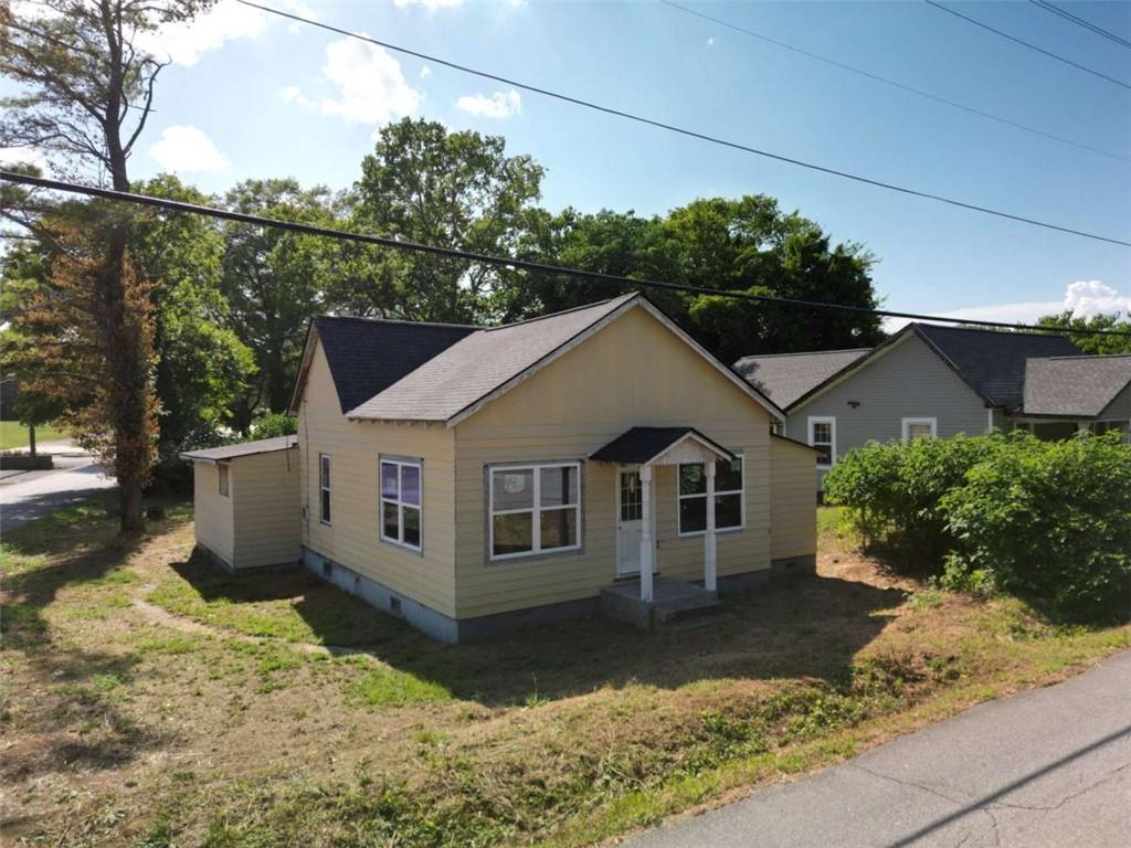 This property presents an excellent opportunity for renovation and customization. Conveniently located just minutes from shopping and dining, the home boasts an updated roof, windows, and heating unit. With lofty ceilings and over 1,500 square feet of living space, it occupies a desirable corner lot. All interior contents are included, and the property is offered for sale in its current condition. Please be aware that some images have been photoshopped to illustrate the home's potential.