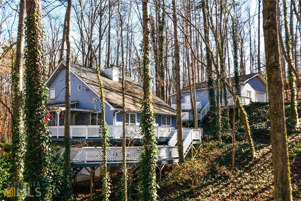 Tucked away in the peaceful Lake Lanier neighborhood of Surfside Club Estates, this updated 2-bedroom, 2-bath cottage is full of charm and comfort-just minutes from downtown Gainesville. Inside, you'll find a bright and welcoming two-story family room, an open-concept layout, and a sunny bonus room perfect for relaxing or working from home. There are two fireplaces to enjoy-one in the main living space and another in the primary bedroom, which also opens to a private screened-in deck with peaceful wooded views. Out back, the spacious deck is ideal for morning coffee, evening hangouts, or weekend get-togethers. Need extra space? The detached 2-car garage doubles as a flexible bonus area with room for beds, a TV, fridge, and games-great for guests or a fun hangout spot. Set in a quiet, friendly community near Lake Lanier, this home is a comfortable escape with room to make it your own. Come see it for yourself!