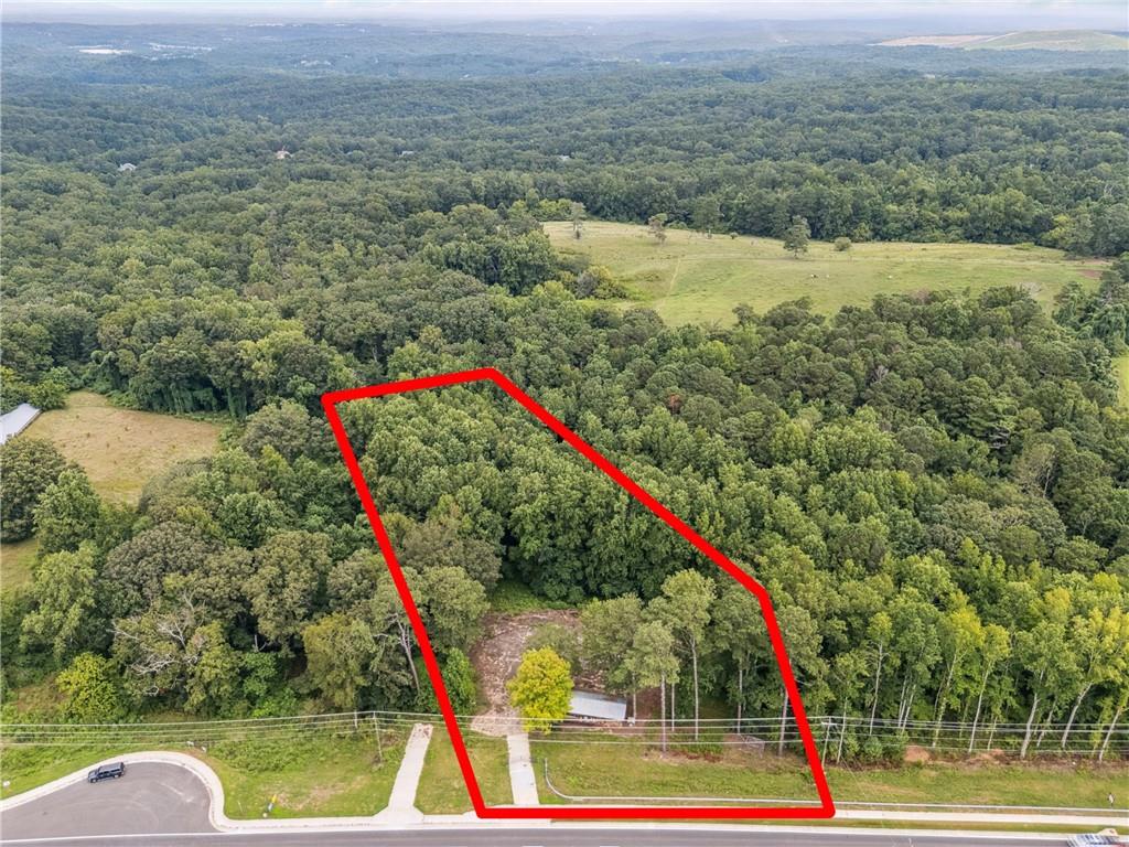 Aerial overview of property's location featuring a heavily wooded area and property parcel outlined