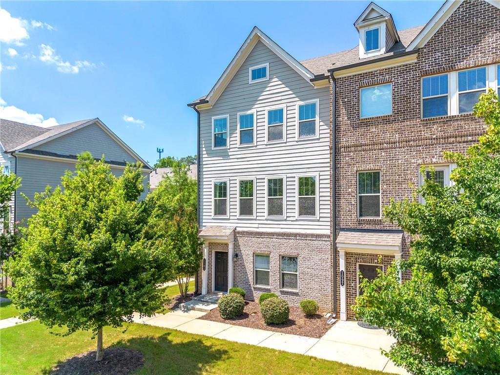 Welcome to Concord Trails in the highly sought after Cobb school district! This end-unit townhome situated on a quiet cul-de-sac features impressive views from front, rear, and side windows. The home has three levels boasting over 2300 square feet. Upon entering you are greeted by a spacious two-story foyer featuring overhead windows for plenty of natural light. This home features beautiful, warm hardwood flooring throughout! The kitchen is a chef's dream, featuring stainless steel appliances, stone countertops, and a stunning oversized kitchen island, complete with bar seating for casual meals or a quick snack. The open-concept layout seamlessly flows into the dining/living and family room areas, making it perfect for entertaining guests or enjoying some family time at home. Just upstairs, the second level hosts three bedrooms including your spacious owner's suite with a luxurious ensuite bathroom and walk-in closets. The lower level, featuring one bedroom and one bathroom, is perfect for your home office, guest room or in-law space. Additional features of the home include a wonderful sunroom on the main level, a two-car garage with rear parking, an upper level laundry room, and a private balcony with peaceful views. This townhome community is located just steps away from the Silver Comet Trail (one of GA's most sought-after trails for running, walking, cycling, and more), shopping, dining, and entertainment, and provides easy access to major highways, making it an ideal location for those who need to commute. Don't miss out on the opportunity to make this stunning townhome yours!