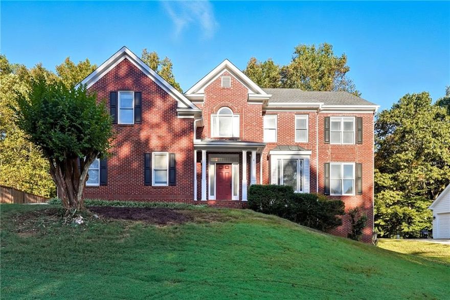 Discover timeless elegance and modern comfort in this beautiful brick home located in The Hamptons Grant, — a quiet, tree-lined community known for its timeless curb appeal and ideal Alpharetta location, with Forsyth Taxes.  Near Avalon, Halcyon, downtown Alpharetta, and top-rated schools, this property combines classic craftsmanship with the conveniences of today’s luxury living.
Step into a bright two-story foyer with gleaming hardwood floors and a striking wrought-iron staircase. The open floor plan flows effortlessly through the formal living and dining rooms into a spacious family room filled with natural light and centered around a cozy brick fireplace — perfect for everyday living and entertaining.
Enjoy the sunny breakfast nook framed by bay windows overlooking the backyard. The kitchen features granite countertops, stainless steel appliances, custom white cabinetry, and a butler’s pantry.
A laundry room with built-in sink and a half bath on the main floor add everyday convenience, making this home as functional as it is elegant. 
Upstairs, retreat to the large primary suite with tray ceilings and sitting area. The spa-inspired bathroom offers a soaking tub, glass-enclosed shower, and dual vanities. Create a closet oasis in the immense primary walk-in closet with natural light. Three additional bedrooms provide ample space for family, guests, or a home office.
The daylight basement offers incredible potential for a home theater, gym, playroom, or in-law suite and features direct exterior access.
Enjoy outdoor living on the expansive back deck overlooking a private, tree-lined yard — ideal for morning coffee or weekend gatherings.
Located on a quiet street with mature landscaping, this move-in-ready Alpharetta home is just waiting for your custom touch.