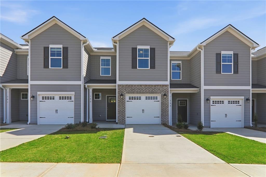 View of front of property with covered porch, a garage, and concrete driveway