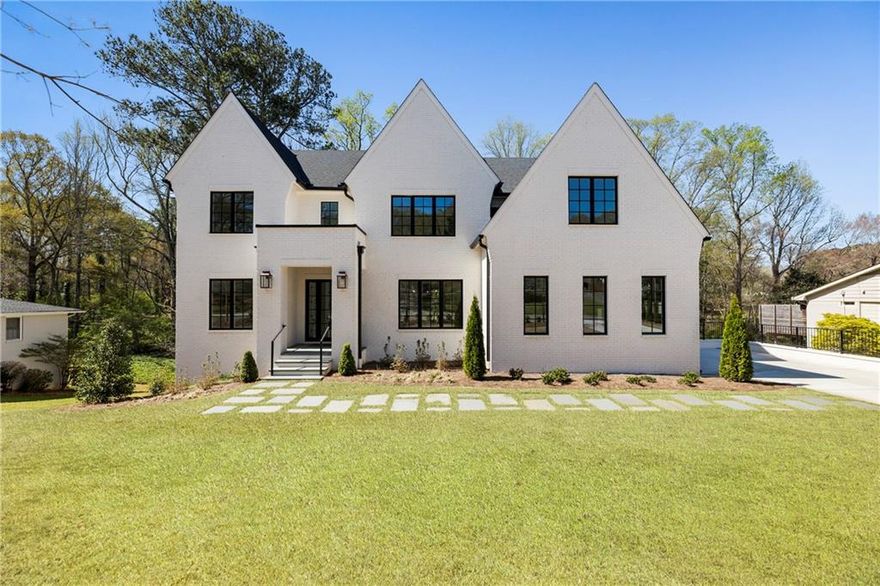 Built by sought-after Madewell, this exceptional home offers a painted brick exterior, high-end finishes, thoughtful design and a prime location near Downtown Alpharetta on a ½± acre lot. A grand foyer with white oak hardwood floors opens to a dining room with custom millwork on a feature wall and a sun-lit office with French doors for privacy. The heart of the home is the combination kitchen and living area. The gourmet kitchen features quartz countertops, a pot filler over the six-burner gas range with a double oven, ceiling-height cabinetry and a large center island with seating and contrasting lower cabinets. Windows line the entire rear of the home and French doors off the kitchen lead to the fireside covered porch. The kitchen flows seamlessly in the casual dining area, defined by a beamed ceiling and subsequently into a fireside living room. The focal point of the room, the fireplace is flanked by beautiful built-in bookcases with a arched details.
The home features two primary suites, one on the main level and another upstairs. The main-level suite includes a spa-inspired bathroom with a freestanding bathtub, separate vanities and a marble-accented shower. The upper-level suite has judges paneling in the spacious bedroom, a tray ceiling with perimeter lighting and a luxurious en suite bathroom with a freestanding bathtub, an oversized shower for two with dual temperature controls, a double vanity with a marble top and a large walk-in closet. A spacious sitting/TV room on the second- level landing provides additional living space along with three secondary bedrooms, each with its own bathroom. A well-appointed laundry room includes a sink, storage and a hanging rack for clothes.
Venture downstairs to discover the fully finished daylight basement, featuring a wet bar, a large recreation room, a living room, a gym and an additional bedroom with an en suite bathroom. A separate pool bathroom with exterior access adds convenience. The basement leads to a covered patio and a custom plunge pool with a waterfall feature and overlooks the sprawling backyard lined with four-board fencing.
Additional highlights include a three-car garage, three laundry rooms and spray foam insulation. A nearby .5± mile trail provides easy access from Downtown Alpharetta shops and restaurants – adding to the home’s appeal. Located in the Cambridge High School district, this home is also close to Avalon, GA-400, Milton and Crabapple. Welcome home!