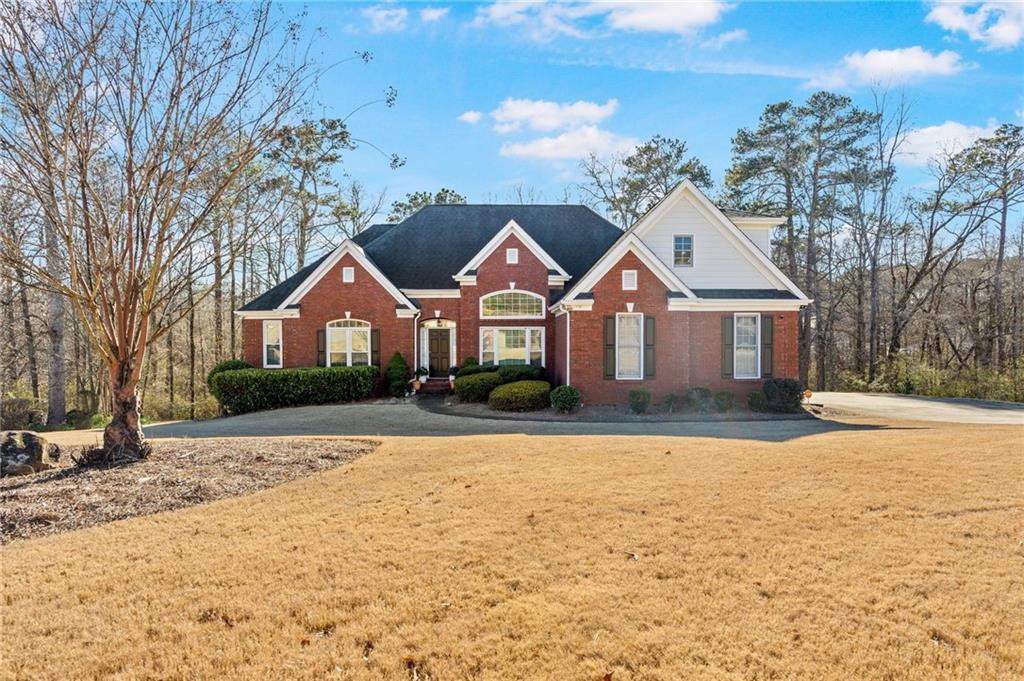Traditional home with brick siding and a front lawn