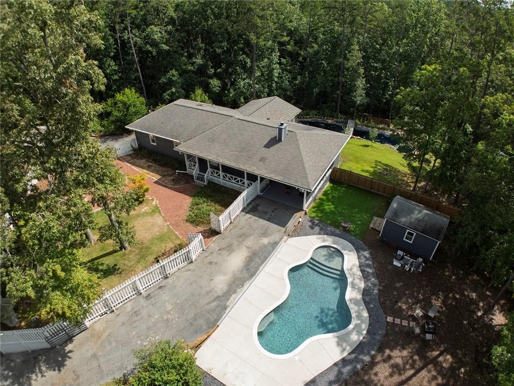 Your Dreams Can Come True! WOW! Come Experience this 5.05 Acre private gated estate (Lot 11) nestled in the woods and out of view, creating the country "Get Away" lifestyle you have dreamed of! Move in Ready! Many NEW-NEW-NEW updates (See list) - Hot tub/Generac can stay! Relax in your NEW HEATED SALTWATER GUNITE POOL, or sit and listen to the "NOISY" WATERFALLS on the 75'X35' - Koi pond in the backyard retreat! Bring your bikes or walk along the babbling creek at the back of the property & watch nature thrive. The apple, Peach, Fig trees, strawberries/blueberries & flowering gardens are delightful. Greenhouse too! Hobbyist will enjoy the 19'X20' DETACHED GARAGE/SHOP building too. There's lot of parking for ALL OF YOUR TOYS and easy access with circular driveways. NO HOA - Pursue your Passions! Finished Rec room/flex space on the terrace level with half bath (stubbed for another full bath) --The perfect place for your future media/theatre room. Many possibilities here-- inside and out! Expandable space on the second lot next door if you want to build a second home - Lot 10 - 5.18 Acres - priced at $ 165K OBO. This is your PRIVATE OASIS in the heart of the Clayton Community of Ball Ground's gorgeous Estate homes! Come see and Fall in Love today!