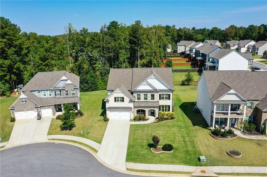 This 2021 Lennar built Wilmington II home offers a spacious 4144+/- sq ft of modern living and natural beauty located in the highly desirable community of Parkside Meadows. Inside, you are greeted by a two story foyer flanked by office/formal living room to your right and large dining room to your left that seats 12+. The heart of the home is the two-story family living area featuring floor to ceiling windows that flood the space with light and serene views of expansive green yard with woods behind. Chefs' kitchen overlooking the family room boasts upgraded granite countertops, S/S appliances, spacious island, walk in pantry and a butler's pantry that connects to the dining area. A mudroom conveniently located by the two-car garage entrance adds practicality. Main level is completed with a guest bedroom ideal for guests or multi-generational living. Upstairs is a luxurious primary suite that includes a spa-like bathroom with separate shower and tub and dual vanities with storage. Three additional generously sized bedrooms, two full bathrooms and a laundry room complete this level. Situated on a quiet cul-de-sac, this property offers one of the best yards in the community. The extended patio is perfect for outdoor entertaining, with picturesque views of fruit trees including fig, peach and pear as well as a weeping willow. Parkside Meadows is more than a neighborhood- it is a lifestyle, with top notch schools, green walking trails, community pool and playground , this is the perfect place for families and outdoor enthusiasts all in prime Cobb County.