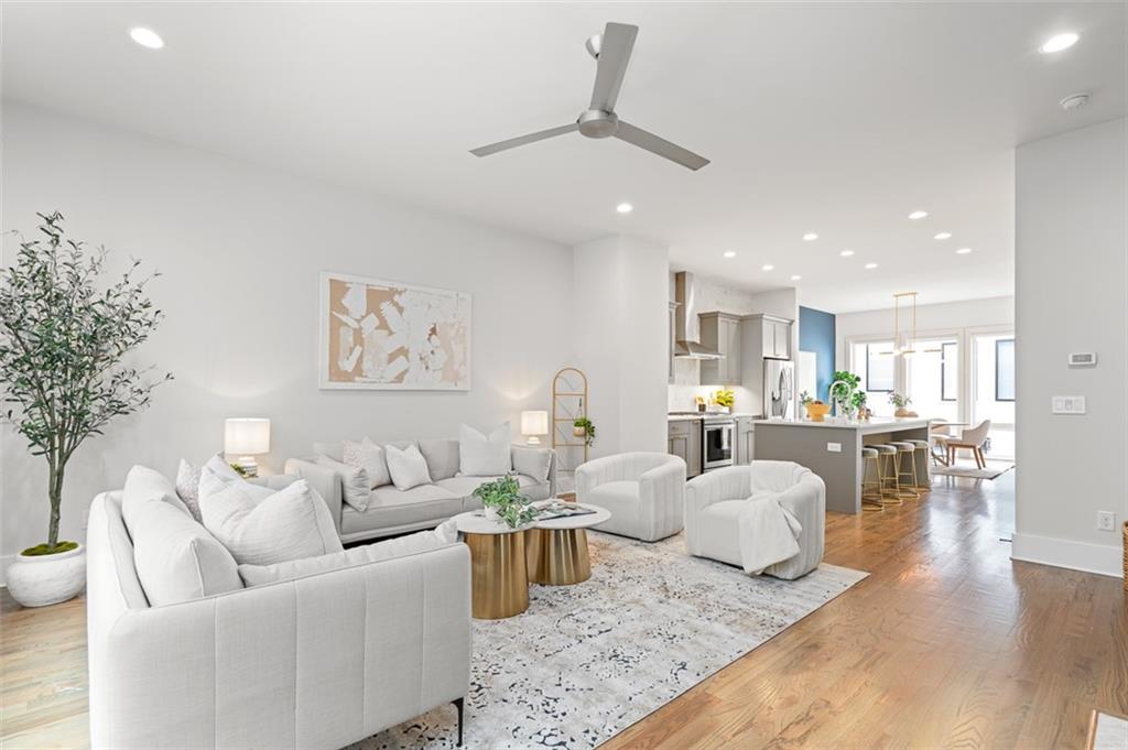 Experience Intown living at its finest in this stunning, three-level townhome bathed in natural light and situated just one block from the Beltline! This nearly new home features a comfortable and open floorplan, thoughtful upgrades throughout, and all of the conveniences of the Madison Yards community in Reynoldstown. On the entry level, you’ll find a welcoming foyer, an extra large bedroom, perfect for an office or den, with a private bathroom, an extra-large hall closet, step-less entry from the 2-car garage, and a small fenced yard. The main level features a spacious living room anchored by a gas fireplace with a marble surround and flanked by custom built-ins and shelving, seamlessly connecting to a private deck with outdoor seating. The chef-inspired kitchen is a masterpiece, showcasing a large quartz island, stainless steel appliances, plentiful cabinetry, a custom full-height backsplash, and two expansive pantries. Adjacent, the dining room impresses with floor-to-ceiling windows and ample space for hosting gatherings. Upstairs, the primary suite offers a spacious walk-in closet with custom shelving, and a well-appointed bathroom with a double vanity with plentiful storage & quartz countertop, a frameless glass shower, and a private water closet. The top floor also houses a second bedroom, complete with walk-in closet and ensuite bathroom, a large laundry room with space for side-by-side machines, and an exceptionally large hall closet. Additional features include new hardwood floors throughout, custom window treatments, ceiling fans and recessed lighting, a main-level powder room, and framing for a future elevator. Conveniently located near the highway and just steps from Publix, Muchacho, AMC, the Beltline & more, this home offers abundant storage, private parking, and a prime location, making it the perfect blend of convenience and modern living!