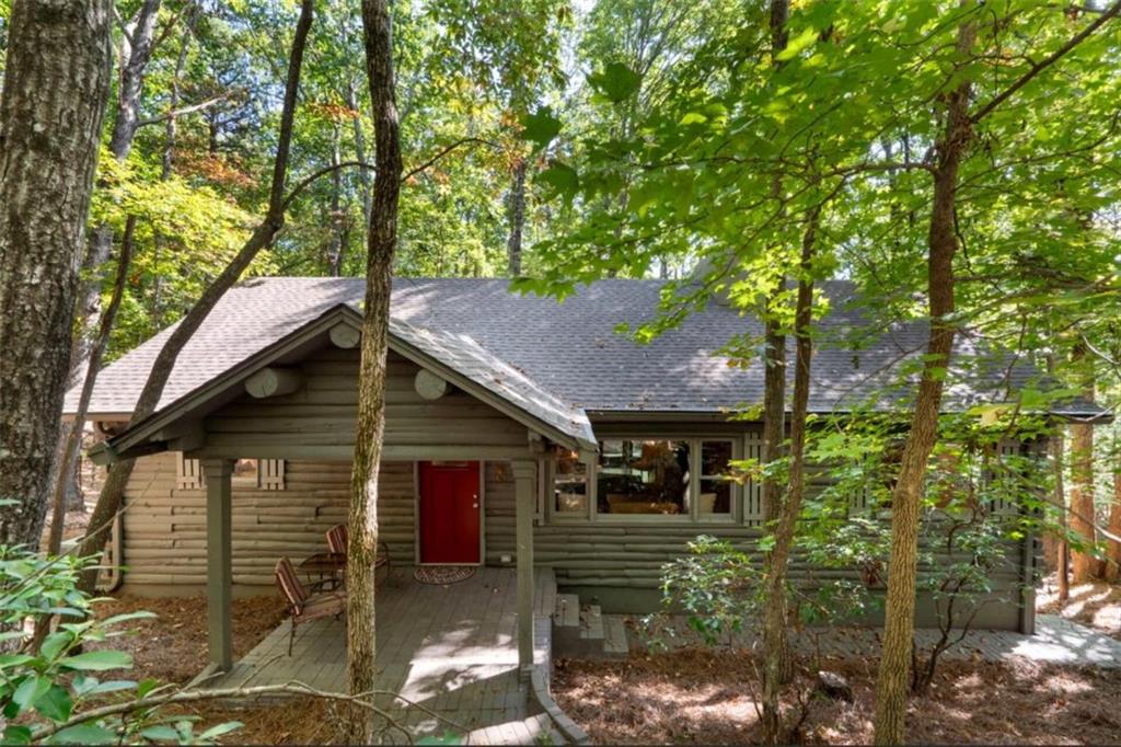This is a light and bright, fully renovated, real log cabin in the award winning Big Canoe community! You'll immediately be impressed with the floor to ceiling, rock fireplace, the genuine log beams that adorn the ceilings and the gorgeous heart pine floors. The spacious and beautifully renovated kitchen boasts granite countertops, stainless steel appliances and enough space to entertain all of your friends and family! The seamless entertainment space leads directly outside to one of two large decks that overlook your own mountain landscape. The loft could be a library, office or 4th bedroom. Once you head down to the terrace level, you'll immediately see another stunning, rock fireplace and the impeccable renovation that is a thoughtful combination of contemporary design while keeping the cabin's original feel. The terrace level deck is ideal for entertaining or just watching the abundant wildlife and fall foliage! You'll be impressed with how well this home has been lovingly maintained. Fresh paint, new carpet, newer roof and so much more! Are you ready to make this log cabin dream a reality? This is an easy YES! Big Canoe is a Golf, Tennis, Pickleball, Lake, Fishing, Boating, Clubhouse, Swim, Hiking and all around AWESOME Community!