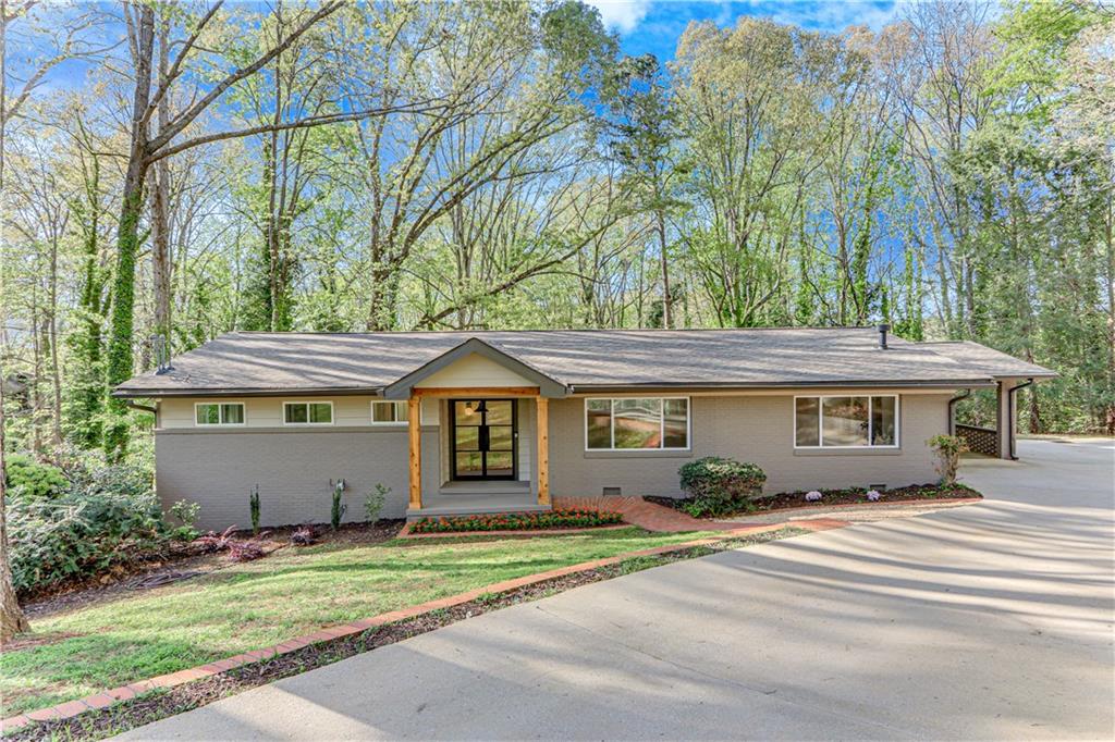 Stunning mid-century in the heart of Gainesville, located on a quiet street in a Lake Lanier neighborhood with seasonal lake views. Enjoy privacy with well-spaced homes and a serene backyard setting. This stunning home features wrought iron exterior doors, a fireplace flanked with built-ins, and a beautifully reimagined island kitchen with custom white oak cabinetry, open oak shelving and quartz counters, with stainless KitchenAid appliances. The main-level owner’s suite offers a luxurious double-headed shower and a custom walk-in closet. The sunroom across the back, with its own exterior entry, is ideal for a home office. The terrace level includes not only living/dining space with a bar, sink and Kitchen-Aid fridge, but also a bedroom suite, a bonus room for hobbies or storage, and a second laundry room. Nearly everything is new: windows, plumbing, electrical, roof—and washer/dryer on main level. A rare blend of timeless style, functionality and location. No HOA. Owners are agents.