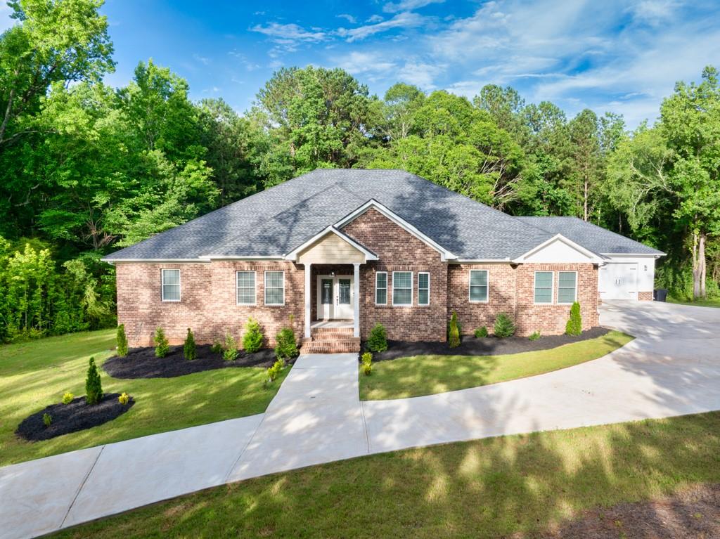 New construction, quality-built home tucked away on just over 6 secluded acres in Oxford, GA. This stunning 5-bedroom, 3.5-bath ranch offers the perfect blend of privacy, space, and functionality. Thoughtfully designed for comfort and efficiency, the expansive floor plan features a large master suite with a spacious bathroom and oversized walk-in closet. Not one but 2 sets of Jack-and-Jill bedrooms. The open concept living area flows seamlessly to a covered back porch. Perfect for entertaining or relaxing in the peaceful surroundings. A 4-car garage provides ample space for vehicles, equipment, or storage. Energy efficiency is a top priority, with spray foam insulation in bot the attic and crawl space ensuring year-round comfort and lower utility costs. As an added bonus, the home directly in front of this property is also for sale, creating a rare opportunity for multi-generational living or extended family to live close by. This is a true retreat offering space, quality, and versatility in a tranquil Oxford setting.