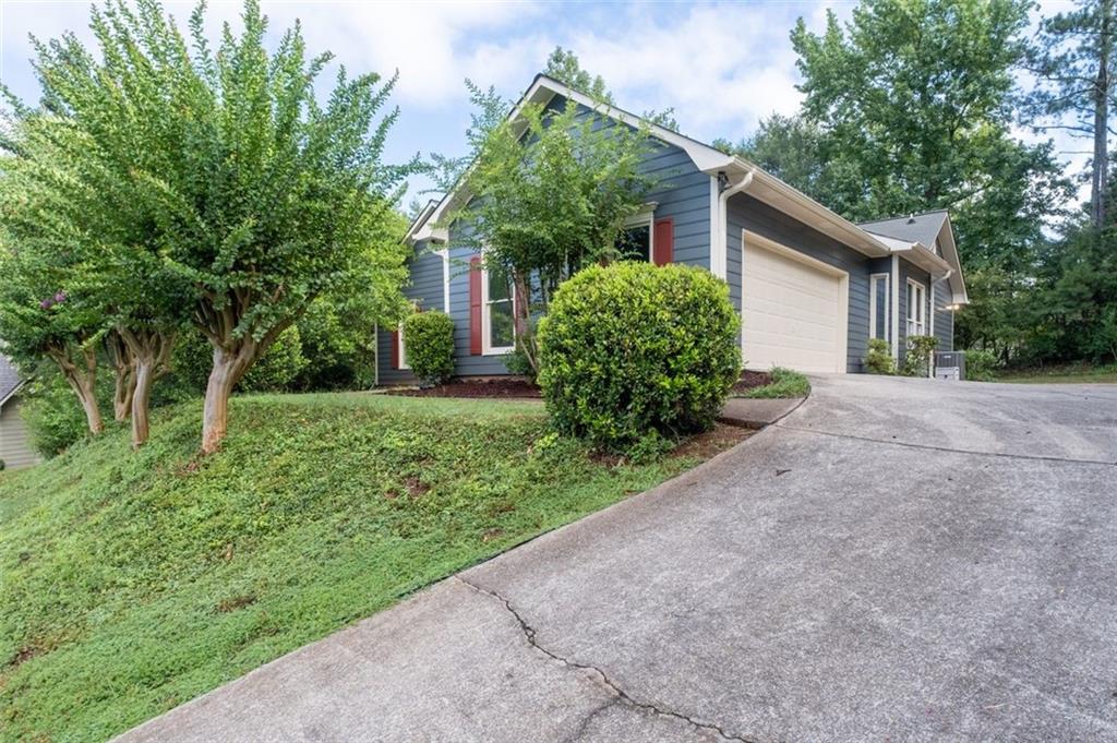 Looking for an affordable, spacious, newly updated home, with great location, established neighborhood and award-winning West-Cobb school district? Then this property is just for you. A beautiful 4/bedroom, 4/full bath, ranch-styled home with a fully finished terrace level is the perfect fit for a large or multi-generational family. Newly painted exterior and interior. Newly refurbished terrace level has exterior patio, new flooring, stairs 2 full bathrooms, 2 spacious bedrooms, office, workshop, and storage area plumbed for a kitchen installation. Notice the real hardwood flooring throughout the main level, including both bedrooms and the soaring 10 ft plus skylight ceilings that enhance a spacious open concept family and dining room floor plan. Enjoy a sunny, light-filled eat-in kitchen w/ breakfast bar, and convenient laundry. The oversized primary bedroom suite on main, includes a spa-like ensuite bath with skylight ceilings, an exceptionally large walk-in clothes closet, trey ceiling, and French doors that open to a screened sunroom. The newly installed deck and refurbished sunroom porch can be accessed from either the family room, primary bedroom or outside. The reward is a morning cup of coffee pleasure as you overlook a private wooded, flat backyard.