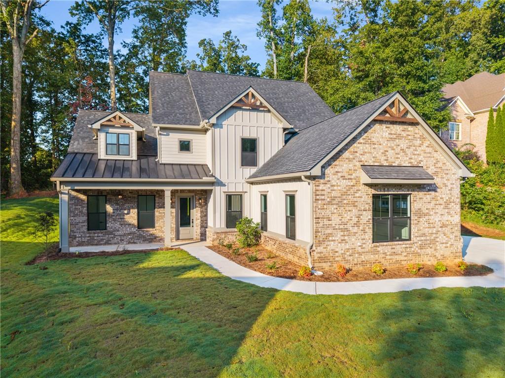 Located in the prestigious Traditions of Braselton, this brand-new construction home offers the perfect blend of luxury, convenience, and modern elegance. Move-in ready, it welcomes you with a charming rocking-chair front porch, an expansive three-car garage, and curb appeal that sets the tone for what’s inside. Step into the soaring foyer, where a versatile flex space awaits—ideal for a home office, playroom, or formal sitting area. The open-concept layout is designed for both comfort and entertaining, featuring top-tier finishes throughout. At the heart of the home, the gourmet kitchen impresses with shaker-style cabinetry, quartz countertops, stainless steel appliances, a wine fridge, a coffee bar, and a spacious walk-in pantry. The kitchen flows seamlessly into a two-story family room with a cozy fireplace and continues to a covered back porch with its own outdoor fireplace, overlooking a level backyard perfect for gatherings, recreation, or quiet retreats. This thoughtfully designed home offers a rare double owner’s suite layout, perfect for multi-generational living. The main-level suite features a spa-like bath with a soaking tub, frameless glass shower, dual vanities, and a large walk-in closet. Upstairs, you’ll find the second owner’s suite, two additional bedrooms, a family room, and a media room, providing plenty of space for everyone. Beyond the home itself, residents of Traditions of Braselton enjoy access to premium resort-style amenities including a fitness center, junior Olympic pool, tennis and pickleball courts, and an on-site restaurant. Conveniently located just minutes from Publix, shopping, and dining, this is an incredible opportunity to own a stunning, move-in ready home in one of Georgia’s most sought-after communities.