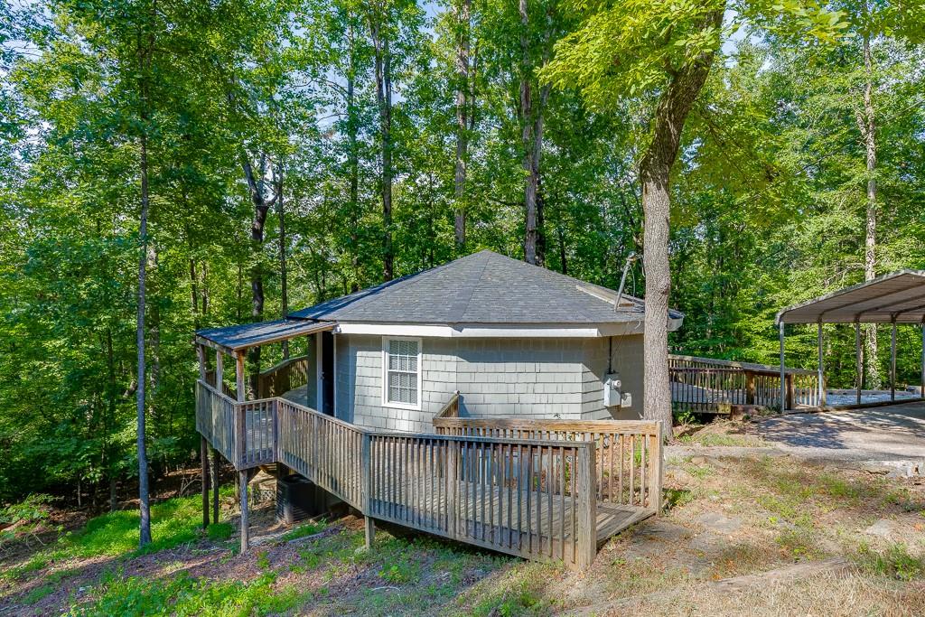 NEWER Roof, NEW HVAC, NEW Septic Tank, NEW Retaining Wall, NEW Flooring, Updated Master Bathroom. Your own TREE HOUSE on LAKE LANIER! 200 feet of beautiful shoreline – perfect for fishing, kayaking, canoeing, and more! Sunny living spaces, ceiling skylights, open-concept floorplan, covered parking, and continuous wrap-around deck. This home is perfect for an everyday residence, investment property, or a quiet weekend get away! No dock/permit.