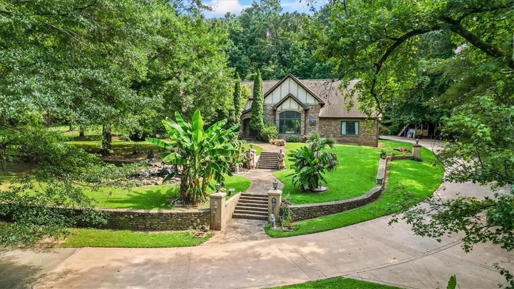 Welcome to this one-of-a-kind gated estate, offering unmatched versatility for short-term rentals, events, business ventures, or private living. Set on 3.62 acres of picturesque land, this rare British Tudor-style home, crafted from elegant brick and stone, overlooks a serene lake, with a second tranquil lake just beyond its borders. Inside, you'll find 4 spacious bedrooms and 3 beautifully designed bathrooms, complemented by stunning architectural features such as marble flooring, 100% wool carpeting, stained glass windows, and exposed wood beams. The home is being sold fully furnished, with unique vintage pieces that enhance its timeless character. A 720 sq ft garage offers ample space for storage, parking, or potential studio conversion. This estate has been featured in numerous film and TV productions, including Netflix's "Dumb Money," Disney+'s "The World According to Jeff Goldblum," and BET's "Magic City," making it not only a beautiful residence but also a proven filming location. Zoned for both office and institutional use, this property offers endless possibilities--ideal for a business retreat, wellness center, creative studio, or live/work setup