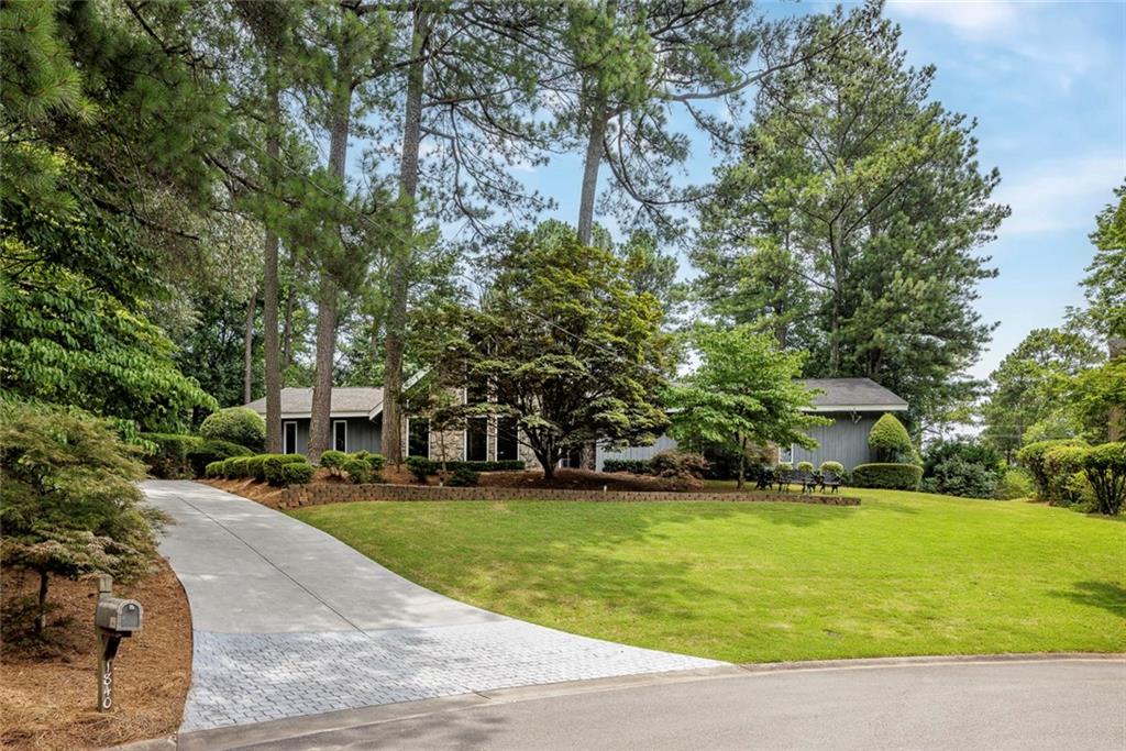 A rare find in Dunwoody! This striking contemporary offers true one-level living with a spacious open floor plan, soaring vaulted ceilings, and dramatic floor-to-ceiling windows that flood the home with natural light. Located on a quiet cul-de-sac and just a short walk to top-ranked Vanderlyn Elementary, this home combines modern style with everyday comfort. Step inside to a vaulted dining room and great room that opens seamlessly to the outdoors and a walkout heated fenced pool—a peaceful, private retreat perfect for relaxing or entertaining. A beautifully designed room addition with custom leaded glass doors adds extra flexibility for living, working, or gathering. The sleek, modern kitchen features Caesarstone countertops, custom cabinetry, and stainless-steel appliances. The oversized primary suite is located on the main level and has been expanded with access to the pool plus a sizable, upgraded bath and a walk-in closet. Additional features include a newer driveway, architectural roof, dual HVAC systems, new pool equipment and a large, powered storage shed— for tools, hobbies, or pool equipment. There's also plenty of space to add a garage or pool house. Thoughtfully updated, meticulously maintained, and close to top schools, Dunwoody Village, shopping, and parks—this is a special opportunity for a one-of-a-kind gem!