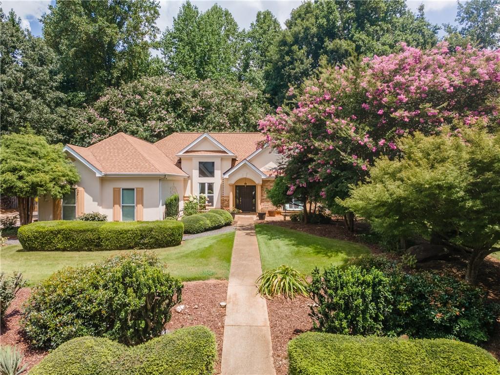 Welcome to this beautiful, stepless Ranch home featuring a split bedroom floor plan and located in one of the best-established neighborhoods Flowery Branch has to offer! Partially open concept, wood burning, stacked stone fireplace with gas starter, separate dining room, large owner's suite with custom closet and a spa-like bathroom that boasts a separate floor to ceiling walk-in, tiled shower and huge soaking tub. In addition, enjoy those cool evenings this fall relaxing in your hot tub, privately located off the screened-in "game day" porch. A gorgeously landscaped yard with lots of privacy in both the front and back create the perfect spot for morning coffee or evening chats with friends and family. Walk the almost three miles of paved walking trails that meander through the woods and alongside the neighborhood's three lakes, tennis/pickleball court, basketball area, playground and swimming pool/club house. Great school district and centrally located to shops, grocery stores, restaurants, library, parks, Lake Lanier (just minutes away) and many different places of worship to choose from. Come take a look for yourself and put your happy house hunting days to an end!