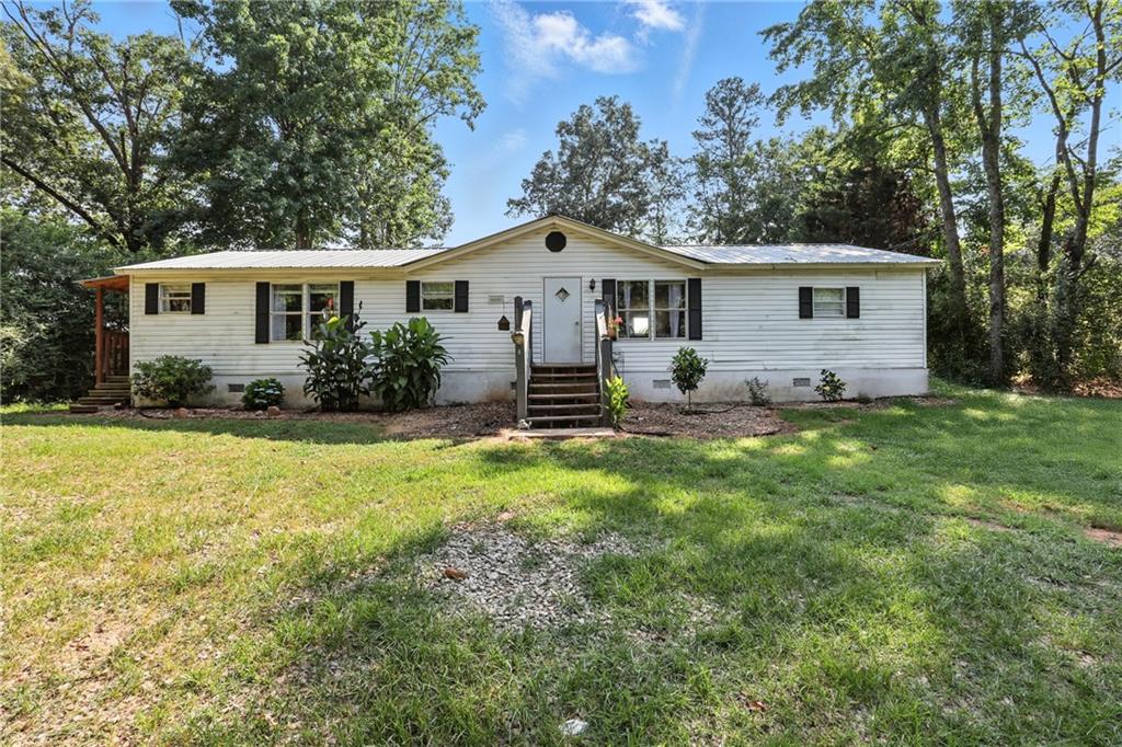 Welcome to your new home! This beautiful three-bedroom, two-bathroom manufactured home is perfect for anyone looking for a comfortable and updated living space. As you step inside, you'll notice the large and spacious living room that opens up to the kitchen. The bedrooms are cozy and comfortable, providing plenty of space for rest and relaxation. The two bathrooms are updated and spacious. The yard is great for outdoor activities, with plenty of room for gardening, playing, or just enjoying the beautiful views of the peach tree farm behind the home. In addition to the great yard, the home also comes with an outdoor building, providing plenty of space for all your storage needs. Newer roof, water heater, and HVAC. Don't miss this one!
