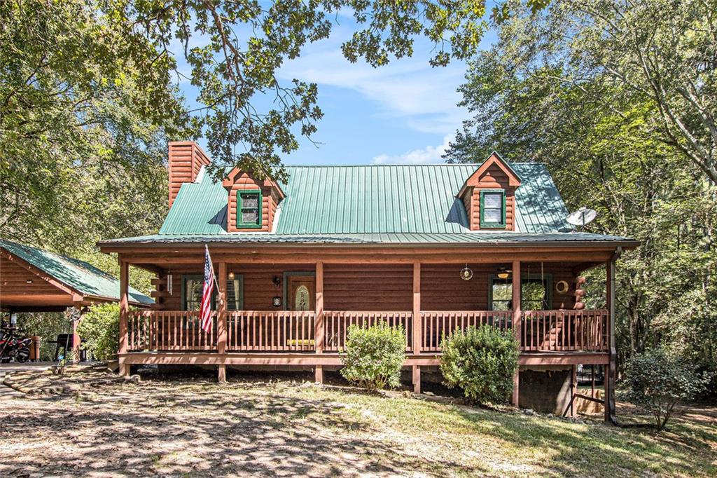 Rustic Charm Meets Modern Comfort on 4 Private Acres. Looking for a retreat that feels worlds away, yet keeps you close to everything you need? Welcome to 4134 Dews Pond Road—a classic log cabin offering timeless character, modern updates, and the ultimate North Georgia lifestyle. Unwind on the spacious rocking chair front porch after a long day and take in the peace and quiet. Step inside to discover an open-concept main floor highlighted by a two-story great room, complete with a wood-paneled cathedral ceiling and a striking stone fireplace with gas logs—perfect for cozy evenings. During the day, natural light streams through the windows, dancing across the oak hardwood floors and filling the space with warmth. The updated kitchen boasts all-new appliances, while thoughtful upgrades throughout—like a new fireplace insert, larger water heater, and modern light fixtures and fans—make this home truly move-in ready. The main floor offers two bedrooms that share a hall bath, while the oversized Owner’s Suite upstairs features a private bath and plenty of space to unwind. A loft-style flex area overlooking the great room provides endless options: office, playroom, library, or an additional lounge. Downstairs, the partially finished walk-out basement includes a spacious laundry room and generous room for a workshop, hobby space, or man cave. Double doors and a secondary driveway provide easy access—ideal for lawn equipment, projects, or storage. Step outside to the large rear deck, perfect for entertaining, overlooking your own saltwater pool and expansive backyard. With 4 acres of established hardwoods, this property offers both shade and privacy. A long driveway and covered carport provide plenty of parking and room for that camper, boat, or extra vehicles.This home delivers the best of both worlds—rustic charm, modern updates, and a setting you’ll never want to leave. 4134 Dews Pond Road isn’t just a home—it’s a lifestyle. What are you waiting for? Schedule your private showing today!