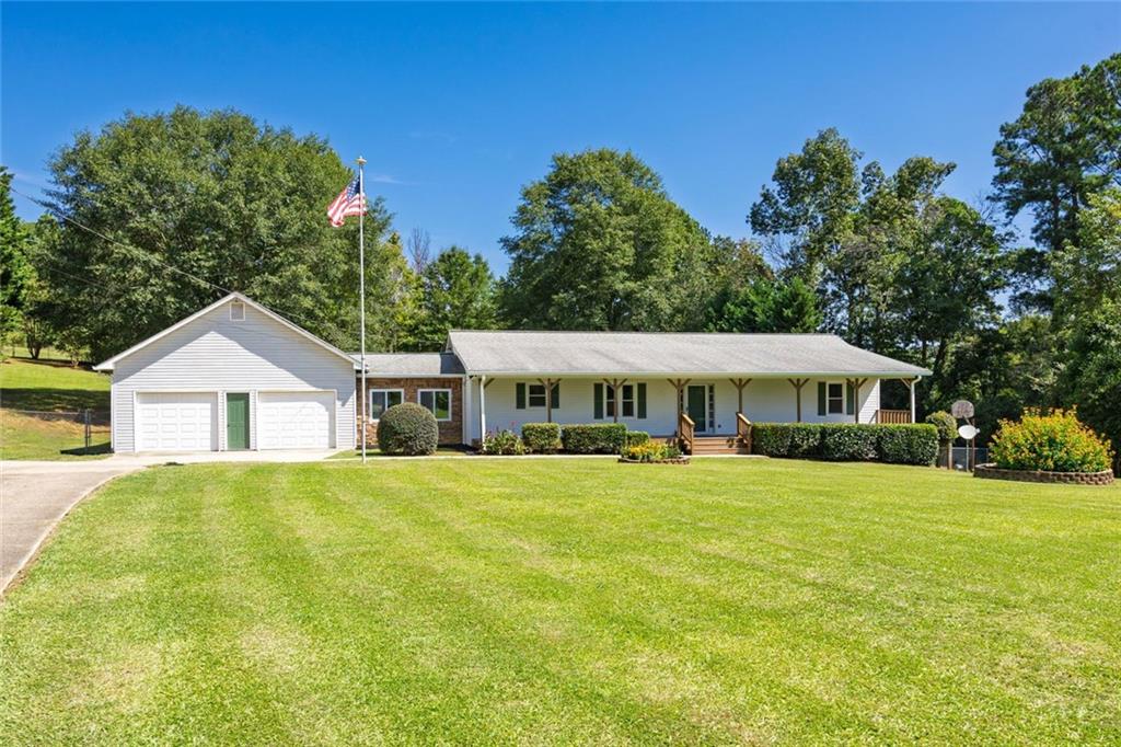 Welcome to your dream home, nestled on 4.33 private acres!
This well-maintained ranch-style home boasts a beautiful 8’ x 56’ covered front porch in a peaceful setting with occasional wildlife visitors. A large screened-in back porch provides the perfect space for entertaining or relaxing while enjoying the soothing sounds of nature.
Inside, you’ll find a spacious eat-in kitchen with oak cabinets and all appliances, including the refrigerator. The master bedroom features his-and-hers closets, and the updated master bath is stunning with an oversized tiled shower, marble countertops, and a double vanity set on a slip-resistant tiled floor.
The two secondary bedrooms are generously sized, each with a walk-in closet, offering comfort for family or guests. A mudroom connects the garage to the home, adding versatile potential—ideal for a home office, utility area, or creative space. It also offers easy access to the one-acre fenced backyard, perfect for pets or children.
The additional acreage provides endless opportunities for recreation, gardening, or future expansion.
The expansive garage is another standout feature, complete with workbenches, attic storage, and ample room for hobbies, tools, and vehicles. Its spaciousness is sure to impress.
Located in the highly sought-after North Paulding School District, this must-see home is within a 20-minute drive of Dallas, Rockmart, Cartersville, Acworth, and Hiram. You’ll also enjoy easy access to the Silver Comet walking and biking trail, Red Top Mountain State Park, and Lake Allatoona. This home combines peaceful living with the convenience of nearby amenities.
Don’t miss the opportunity to fall in love with this charming ranch-style home that offers plenty of breathing room and elbow space!