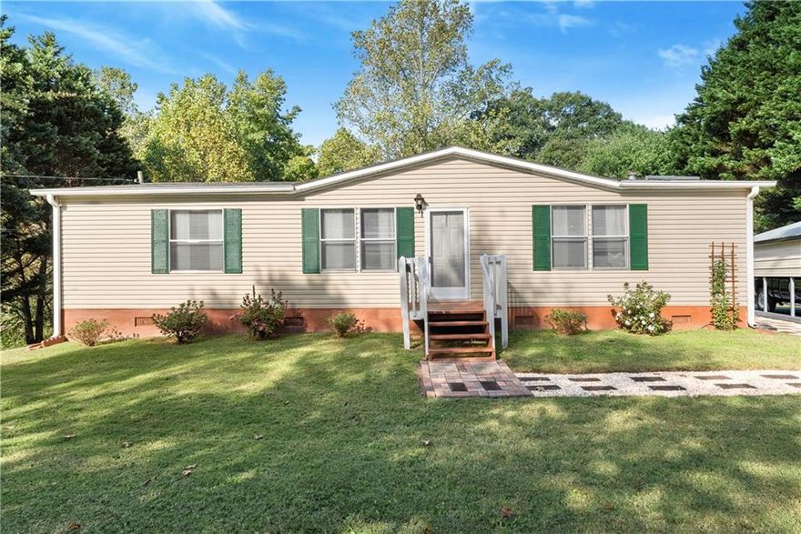 Perfectly maintained 3-bedroom, 2-bathroom home on just over one acre lot within the highly sought-after East Forsyth School district! This home offers a spacious and inviting floor plan with a cozy living area with a fireplace, a nice kitchen with plenty of cabinet space, and a comfortable primary suite with a private bath. Many recent updates include a new HVAC system, water heater, flooring, and walk-in shower in the primary suite. Two large carports and a shed provide areas for vehicles or a workshop. Enjoy peaceful country living with plenty of room for outdoor activities, gardening, or future improvements. Located just minutes from shopping, dining, and Lake Lanier, this property combines privacy and convenience. Move-in ready and well cared for—don’t miss your chance to make this one your own!