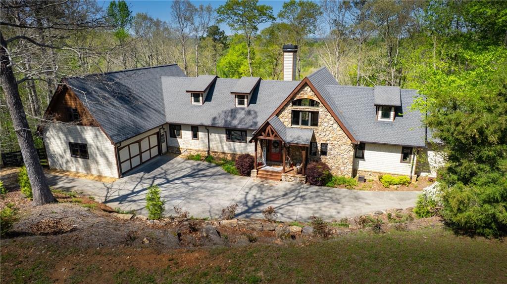 Nestled on over 2 PRIVATE, WOODED ACRES with an option to purchase an additional 2+ acre parcel to expand this GORGEOUS ESTATE. Located in Forsyth County's exclusive ETOWAH TRAILS with DIRECT TRAIL ACCESS to the ETOWAH RIVER and LONG-RANGE VIEWS of the NORTH GEORGIA MOUNTAINS, this EXQUISITE CUSTOM TIMBER FRAME home is PRICED WELL BELOW APPRAISED VALUE! Conveniently located minutes from BALL GROUND, CUMMING, POOLE'S MILL PARK, GIBBS GARDENS, and MORE!
Designed by MILL CREEK POST and BEAM, the home features SOARING VAULTED CEILINGS, WIDE-PLANK PINE FLOORS, HANDCRAFTED IRONWORK, and MASSIVE EXPOSED BEAMS. The EXPANSIVE GREAT ROOM features a TWO-SIDED STONE FIREPLACE and GORGEOUS WALL-TO-WALL WINDOWS which showcase the river valley and North Georgia Mountain view. Fine finishes include TONGUE AND GROOVE CEILINGS, SOLID ALDERWOOD DOORS, EXQUISITE IRON DETAILS and many more. Designed for energy efficiency and built to last centuries, the home is enclosed in STRUCTURAL INSULATED PANELS which provide high R-Values and LOW energy bills. The cost to build this home today is well over 2M.
The heart of the home is the GOURMET KITCHEN, with an 8-foot island and tons of cabinet space. Designed with the family chef in mind, high-end GE MONOGRAM appliances, GRANITE countertops, a SIX-BURNER cooktop, WARMING DRAWER, ADVANTIUM SPEED COOK OVEN, and GORGEOUS WALK-IN PANTRY will make cooking a joy. The OVERSIZED DINING AREA, also centered around the FIREPLACE, offers the PERFECT SPACE FOR ENTERTAINING with a fire and a view!
Designed for ranch living, the MAIN-LEVEL PRIMARY SUITE features PRIVATE DECK ACCESS, a SPA-INSPIRED BATHROOM, and a CUSTOM WALK-IN CLOSET. Two additional main-floor bedrooms share a JACK-AND-JILL bath. A half bath and a LARGE LAUNDRY ROOM with BUILT-INS, complete the main floor. At one end, a LOFTED OFFICE or COZY READING SPACE overlooks the GREAT ROOM, while at the other end of the house, a PRIVATE SUITE with a LUXURY BATH, WALK-IN CLOSET, and EXPANSIVE BONUS ROOM offers FLEXIBILITY as a FIFTH BEDROOM or BONUS ENTERTAINMENT SPACE.
The nearly 3,000 SQ FT UNFINISHED BASEMENT is already INSULATED and FRAMED with a FIREPLACE INSERT, offering ENDLESS POTENTIAL for CUSTOMIZATION.
Outdoors, enjoy 900 SQUARE FEET OF DECKING, a FENCED PADDOCK for dogs or ponies, and SERENE NATURAL SURROUNDINGS with direct access to the community WALKING and EQUESTRIAN TRAILS along the ETOWAH RIVER.
Additional features include an OVERSIZED 750+ SQ FT GARAGE, COPPER GUTTERS, TANKLESS WATER HEATER, and PELLA ARCHITECTURAL DOUBLE-PANE CASEMENT windows with wide overhangs.
Zoned for TOP-RATED FORSYTH COUNTY SCHOOLS and eligible for the FORSYTH COUNTY SENIOR TAX EXEMPTION, this home perfectly combines PRIVACY, the TRANQUILITY OF NATURE and LUXURIOUS LIVING close to MODERN CONVENIENCES. This is your OPPORTUNITY to OWN a TRUE NORTH GEORGIA MASTERPIECE. This quality of home doesn't come on the market very often!
SCHEDULE YOUR PRIVATE SHOWING TODAY!!!