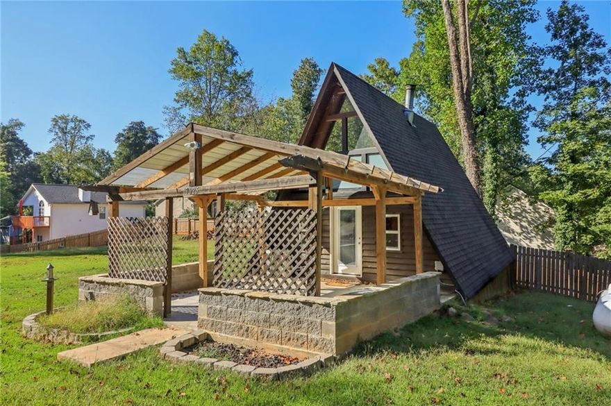 Discover this charming A-frame nestled on a spacious lot just minutes from LAKE LANIER! With no HOA, the possibilities are endless as you're able to design an outdoor space to meet your needs. There's room to add a pool, storage shed, or utilize the ample space for RV/boat parking, and more. The perimeter of the property is fenced, with the option to fully enclose, making it perfect for pets and privacy. The covered front patio adds additional living space for easy indoor-outdoor living. Whether styled with comfortable seating, a mounted TV, or fire pit, it’s the ideal place to relax and entertain as cooler weather approaches. Inside, this home exudes COZY RUSTIC CHARACTER with great potential. A NEW SPLIT-UNIT heating and cooling system serves the two-level layout, which features EXPOSED BEAMS, butcher block countertops, a herringbone tile backsplash, and stainless steel appliances. The main level also includes a laundry room with storage and pantry, while the loft offers flexible space for a possible second bedroom, home office, or additional storage. This property is a RARE FIND, whether you’re seeking a personal lake getaway, INVESTMENT OR RENTAL PROPERTY. Nearby access to Two Mile Creek Boat Ramp, Bethel Park, Vans Tavern Park, and Pelican Pete’s, plus convenient proximity to grocery stores, shopping, and dining. It’s the perfect blend of seclusion and accessibility.