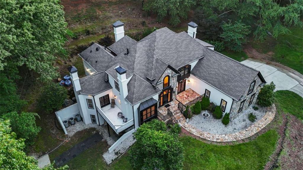 Experience timeless elegance and rare riverfront privacy on 13 pristine acres with direct access to the Yellow River. This luxury estate offers grand entertaining spaces, high-end finishes, and flexible multi-generational living across three levels. A dramatic two-story foyer with white and gold tile and a curved staircase sets the tone for this exceptional home. The sunken formal living room features 12FT ceilings, black lacquer floors, and a gold and white stone fireplace, while the formal dining room comfortably seats 12 and is wrapped in gold fabric wallpaper. The gourmet kitchen is a chef's dream: gas and electric cooktops (4 burners each), stone counters, double ovens, two dishwashers, a hidden pantry, prep sink, recessed lighting, built-in bookshelf, and a cozy breakfast nook with bay windows and stone fireplace. The main-level primary suite includes a sitting area, private balcony, fireplace with porcelain surround, and views of a peaceful koi pond. The spa-inspired bathroom features heated/cooled porcelain floors, floor-to-ceiling tile, a 6-ft floating vanity, LED mirror, 5-head shower, freestanding Kallista tub, and Kohler bidet toilet with electric controls. Dual closets and access to a semi-finished attic (ideal for expanding to a two-story closet) complete the suite. Upstairs offers two renovated en-suite bedrooms, a third large bedroom with walk-in closet and window seat, a full hallway bath, a game room or potential bedroom, and a walk-in attic. Bathrooms include floating vanities, LED mirrors, recessed lighting, tiled showers, and designer finishes. The finished basement offers a private bonus room with skylight windows, a 8-ft island/bar, under-stair storage, full bathroom, laundry, and an LED light feature in progress. A separate basement apartment includes two bedrooms (one en-suite), a full kitchen, living room, and private entrance with separate driveway-ideal for guests, in-laws, or rental income. Additional highlights: * 3 driveways including Bernard Rd access * Tri-zone HVAC with 3 AC units * 2 gas water heaters (2009) * 3 full bathrooms upstairs * 1 full bath with laundry on main * Laundry in basement * Office with oversized window * Rain guards on gutters * Private back staircase from kitchen * Walk-in attic , Multiple fireplaces (living, kitchen, and primary). This home is built for both elevated everyday living and grand-scale entertaining. From luxury finishes to practical amenities and unforgettable Yellow River views, this estate is more than a home, it's a lifestyle.
