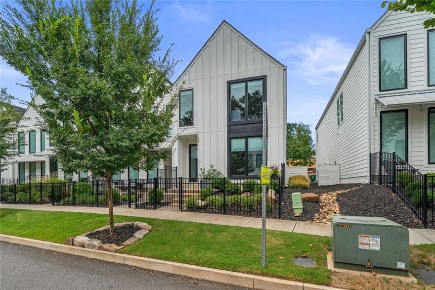 Walk or ride your golf cart to Downtown Woodstock!!  Luxury townhome with all the conveniences is one of Georgia’s most desirable places to live.  Meticulous, nearly new luxury townhome offers designer upgrades throughout.  The foyer entry is large and welcoming accessible from the front door or the garage.  Extra-large windows throughout complete with adjustable shades, allowing so much natural light, massive, vaulted ceilings, remote controlled ceiling fans, to the open concept living area with custom features including a contemporary electric fireplace, luxury flooring, accent walls.  Your upgraded kitchen includes painted cabinets, stainless appliances, a huge island for entertaining, food prep, extra seating, walk in pantry and so much more. The entry level features a full bedroom with a full bath, custom tiles, and large closet – could be your work from home office, guest suite, den, media room – your choice.  The primary suite features three (3) closets and covered back porch access (furniture included) and a spa like bath with oversized upgraded tiled shower and dual sink vanity.  The professionally landscaped, gated front yard allows you that maintenance free lifestyle.  Ride your golf cart or walk to the community amenities including a pavilion with grills, firepit and a dog park. Just a few minutes more and you are in Downtown Woodstock for dining, shopping, entertainment and the amphitheater.  Costco, premium outlets, the farmers market, parks and trails just moments away!