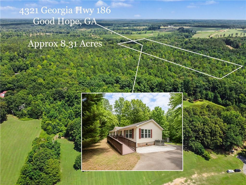 Expansive wooded acreage featuring a single-story residence with a tan exterior, red shutters, and an accessibility ramp