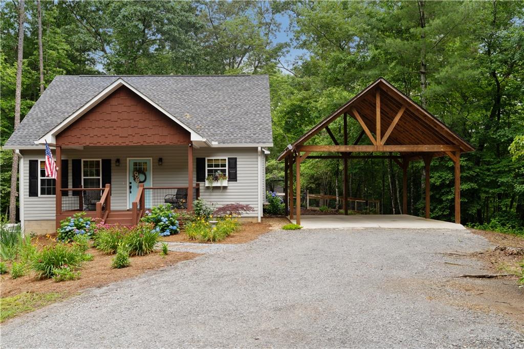 Welcome to your private FURNISHED farmhouse mountain retreat in the exclusive 8-lot community of Chimney Ridge, where there’s no HOA and covenants are set to expire in 2026. Perfectly situated on 1.5 secluded acres just six miles from downtown Ellijay, this impeccably built 1-bedroom, 1.5-bath custom home blends modern luxury with tranquil mountain living. Built in 2020, the one-level layout features luxury vinyl plank flooring, granite countertops, stainless steel appliances, custom white wood cabinetry, a walk-in pantry, a wood-crafted vent hood, and a tile backsplash. The open-concept living space includes a gas log fireplace with a shiplap accent wall and a whole-home wired sound system that extends to the living room, both bathrooms, and porches. The spacious primary suite offers an oversized walk-in closet with an office nook, a barn door, a tiled shower, a custom vanity, and a stylish seagrass bed. Additional features include a half bath, linen closet, and a large unfinished attic with 16-foot ceilings, providing potential for two additional bedrooms. The expansive covered back porch is ideal for entertaining, complete with a gas fireplace, mounted TV, and fully equipped outdoor kitchenette with a fridge, grill, toaster oven, and storage. The fenced backyard features a firepit, rain barrel garden, and low-maintenance landscaping with roses, hydrangeas, lilies, Black-eyed Susans, purple coneflowers, and a dwarf Japanese maple that return each year. Additional improvements include a 12x30 metal RV carport with a 40-amp hookup and parking pad, a 20x24 wooden two-car carport, a 9x12 powered greenhouse, an 8x12 powered outbuilding, and an 8x16 insulated workshop. The home also offers a private well and septic, tankless gas water heater, propane for the stove, fireplace, hot water, and heat, a whole-house generator installed in 2021, high-speed ETC internet, and strong cell service. Whether you’re looking for a full-time home, a luxurious vacation property, or a turnkey short-term rental, this exceptional home delivers comfort, style, and versatility. Home is being sold furnished with a good offer with the exception of items on the exclusion list.
--
