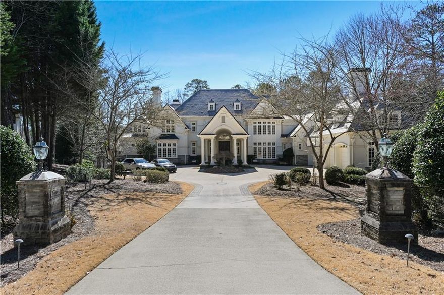 Welcome to your dream home nestled in a tranquil cul-de-sac, set within the exclusive and coveted Country Club of The South gated community, with unparallel views of the Chattahoochee River that flows down from the mountains of north Georgia. This European white stucco masterpiece rests on over one private acre with lots of privacy. From the moment you approach the home, you will feel the sense of luxury and grandeur with an inviting and oversize driveway, that features majestic columns and 35-foot p rte-cochere entry and 4 car garage. This remarkable estate boasts stunning landscaping and hardscaping, creating a picturesque setting that blends seamlessly with the breathtaking natural surroundings. The welcoming 8-foot double stained wood doors, lead to a grand foyer with soaring 22-foot barrel ceiling and twin elegant wrought iron curved staircases. Custom benches and travertine floors lead to the magnificent formal living room with soaring fireplace and windows, overlooking the secluded and stunning backyard with tranquil views of the river for ultimate living. With a primary suite on main, office and elevator to all floors, this home brings modern convenience with an opportunity to enjoy all the amenities it has to offer. Banquet size, dining room with butler's pantry. Informal breakfast room adjacent to the glass curved windows in the family room both, with views of the backyard and featuring one of 7 fireplaces. Sophisticated easy living modern kitchen with high end appliances that includes double Sub-Zero fridge and freezer, wolf cooktop, double ovens, warming drawer, walk in pantry and very extensive quartz countertops island. The luxurious Primary Suite, offers windows on two sides to enjoy the views of the Chattahoochee river, fireplace, sitting room and a private veranda with tranquil views. The bathroom features a whirlpool soaking tub, dual sinks, a make-up vanity, two private water closets. Two walk-in closets with floor to ceiling extensive cabinetry and secret access to the library office. In the sitting room, a private spiral staircase next to the elevator, allows access to the exercise room and terrace level. Second Primary Suite also conveniently located upstairs featuring 3 more bedrooms in addition to a private en-suite bedroom with fireplace. Terrace level offers the ultimate entertaining space for fitness and relaxation. Sauna, steam room, exercise room and extra space for a potential golf simulator, media room, and a complete en-suite bedroom. Large area with pool table, bar area, fireplace and easy access to the lush backyard. The pool area with covered outdoor kitchen, jacuzzi and large pool overlooking the river is the ultimate entertaining space. This extraordinary home located in John's Creek have excellent public and private institutions. The lifestyle in this exclusive, gated community includes The Jack Nicklaus-designed 18-hole golf course, brand-new $3 million clubhouse and pool, complete with an Olympic-size pool, kids' slides, and water park. Tennis and pickleball courts, social events, and an elite country club lifestyle. With proximity to downtown Alpharetta and Avalon for shopping, restaurants and entertaining along with access to parks and recreation nearby. You can have it all in Johns Creek.