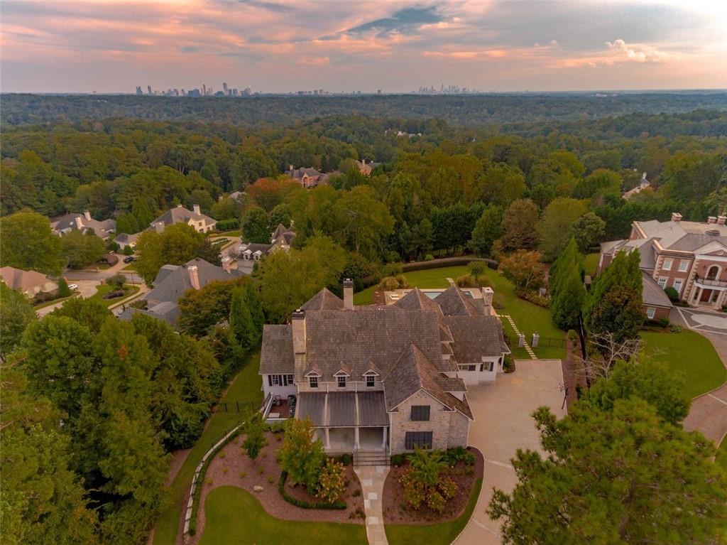 DO NOT DRIVE ONTO PROPERTY WITHOUT AN APPOINTMENT! Opportunities like this don’t come along often….Perfectly positioned on one of the highest points in Atlanta, this meticulously designed custom creation on 1.7 acres provides skyline views that only a handful of other homes in the entire metro area possess! The home itself is equally as stunning as the view. From the gas lanterns adorning the front doors, to the pool and spa overlooking the city, and everything in between, it is perfection. Easily one-level living, the main floor consists of a fireside dining room and living room; gourmet kitchen; sunroom with air purification system; bar; built-in desk; laundry; 2 powder rooms. The exceptional main floor owner's retreat offers a luxurious bath and skyline views. Numerous doors open to a covered patio with fireplace and grilling station, as well as an uncovered patio area. The ideal flow for entertaining and viewing the skyline, both night and day. Upstairs houses 3 large guest rooms, each with a private en-suite bath. A recreation room, 2nd laundry and storage area (which could easily be converted to additional living space) complete the upper level. The basement awaits your customization. The views from this home are spectacular and best seen in person!